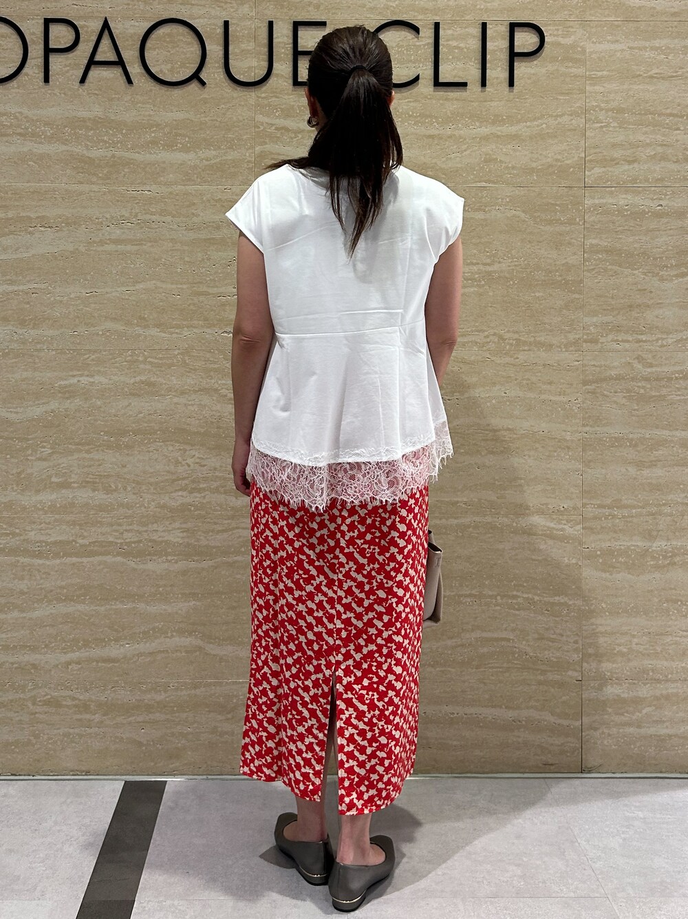 ホワイト系のTシャツ/カットソー、レッド系のスカート、ベージュ系のトートバッグを着用したレディースの夏コーディネートの3枚目の写真