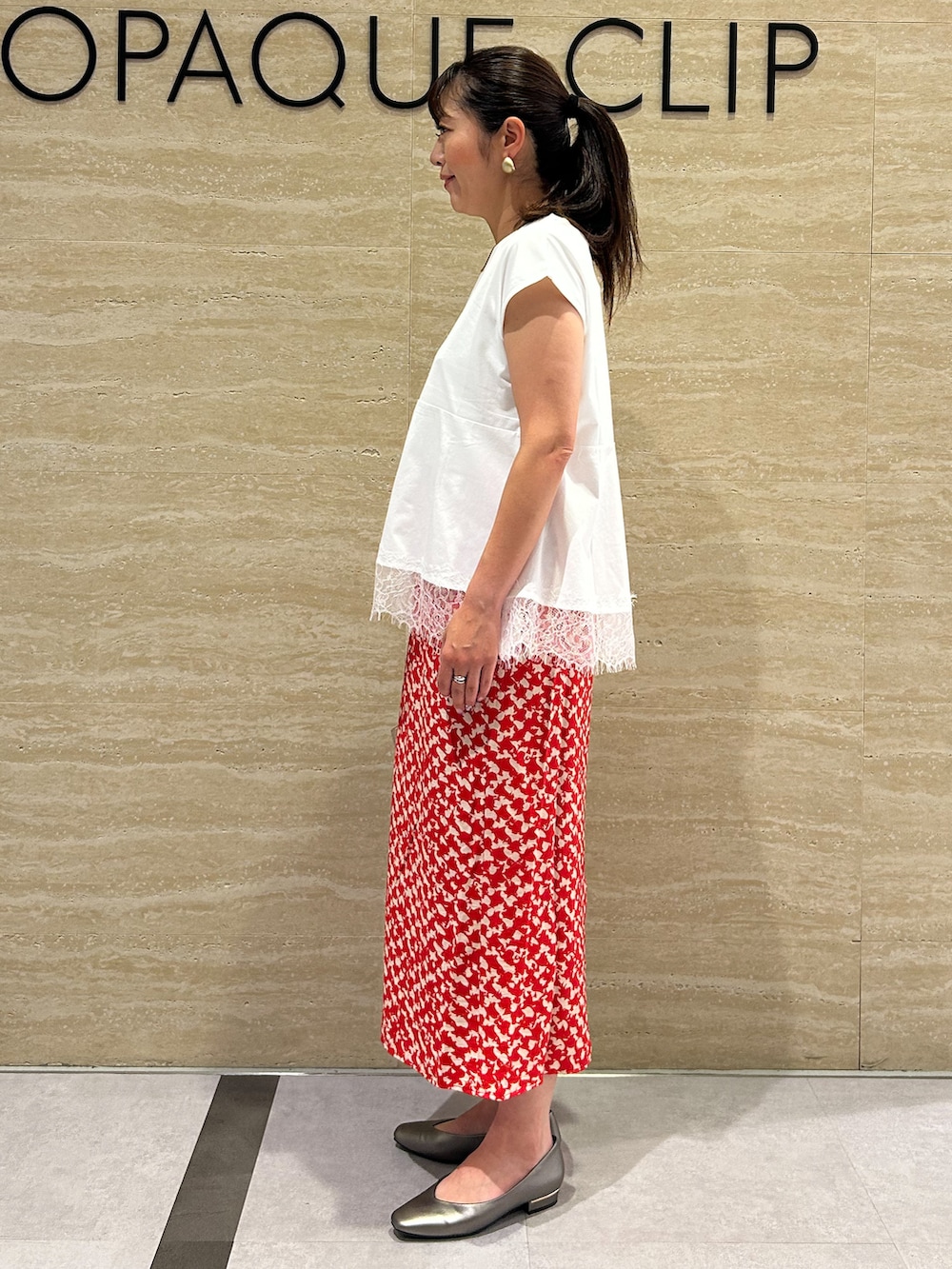 ホワイト系のTシャツ/カットソー、レッド系のスカート、ベージュ系のトートバッグを着用したレディースの夏コーディネートの2枚目の写真