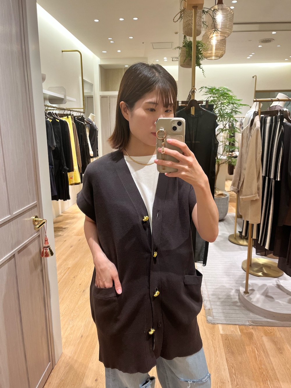 ブルー系のカーディガン/ボレロ、ブルー系のデニムパンツ、ホワイト系のタンクトップを着用したレディースの夏コーディネートの2枚目の写真