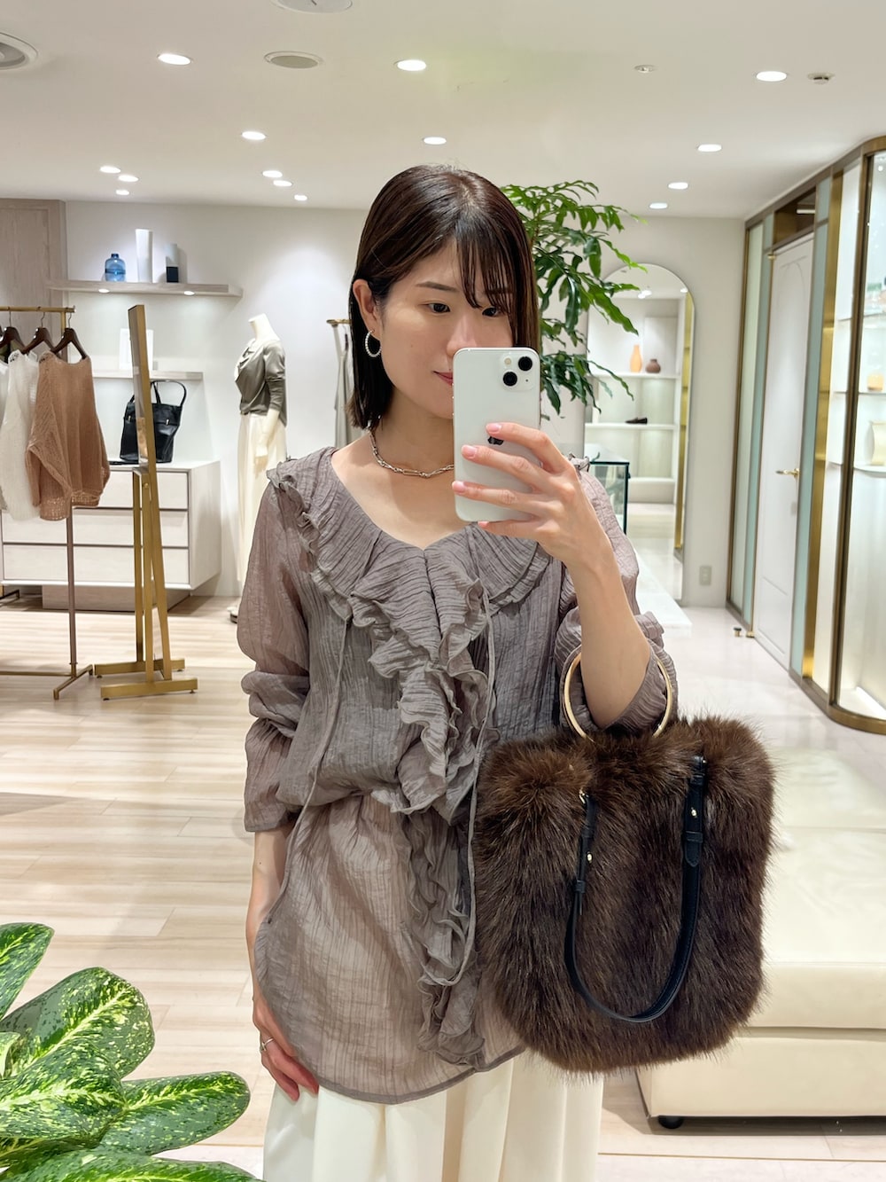 グレー系のシャツ/ブラウス、ブラウン系のトートバッグ、ホワイト系のその他パンツを着用したレディースの秋コーディネートの2枚目の写真