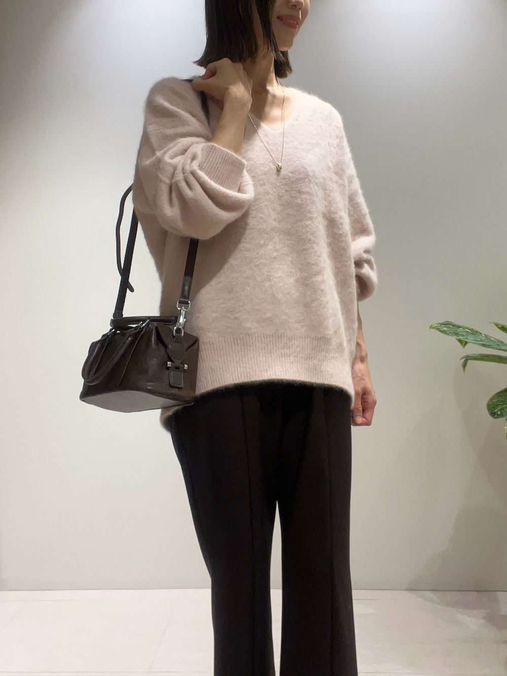 ピンク系のニット/セーター、ブラウン系のその他パンツ、ブラック系のパンプスを着用したレディースの秋コーディネートの2枚目の写真