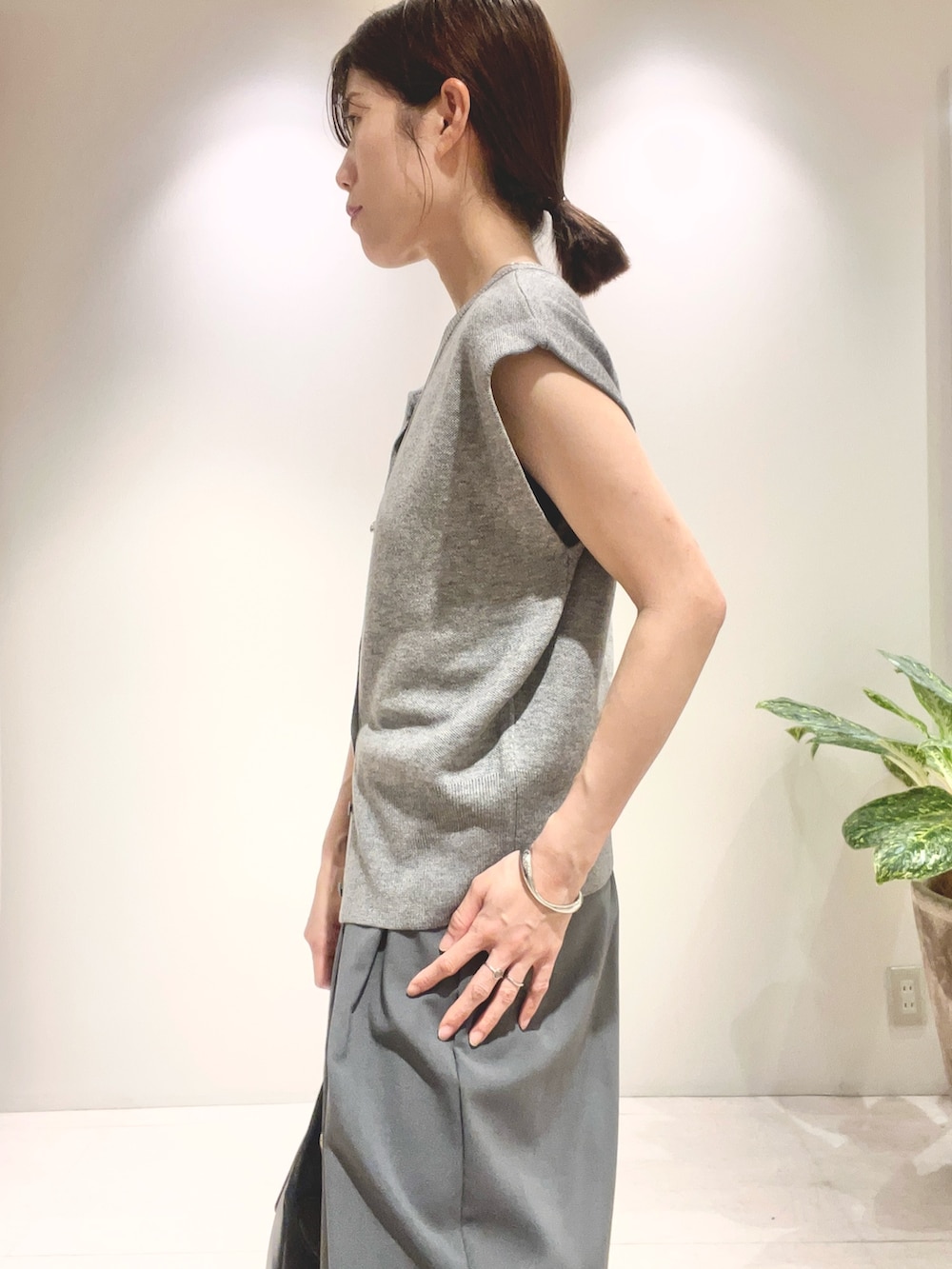 グレー系のその他パンツ、グレー系のニット/セーター、ブラック系のショルダーバッグを着用したレディースの夏コーディネートの3枚目の写真