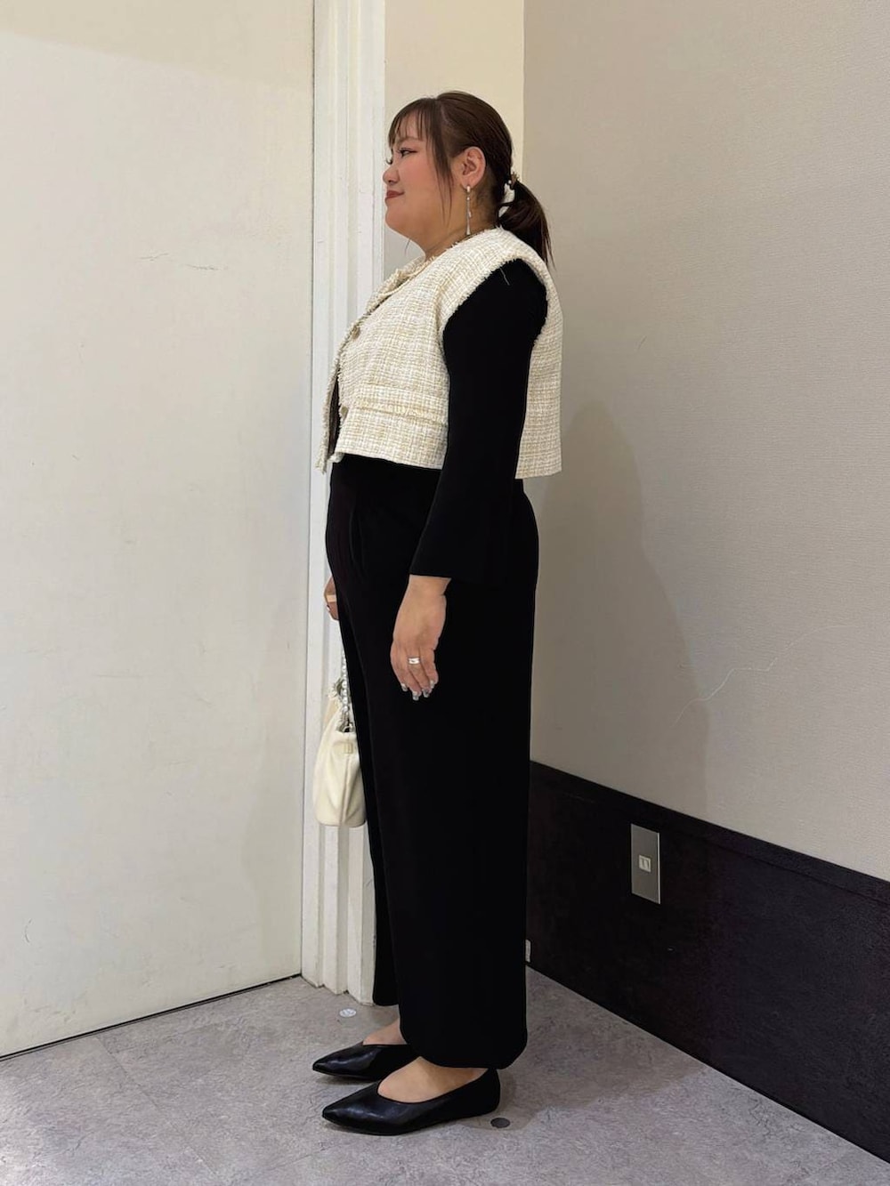 ベージュ系のその他アウター、ブラック系のサロペット/オーバーオール、ブラック系のパンプスを着用したレディースの冬コーディネートの2枚目の写真