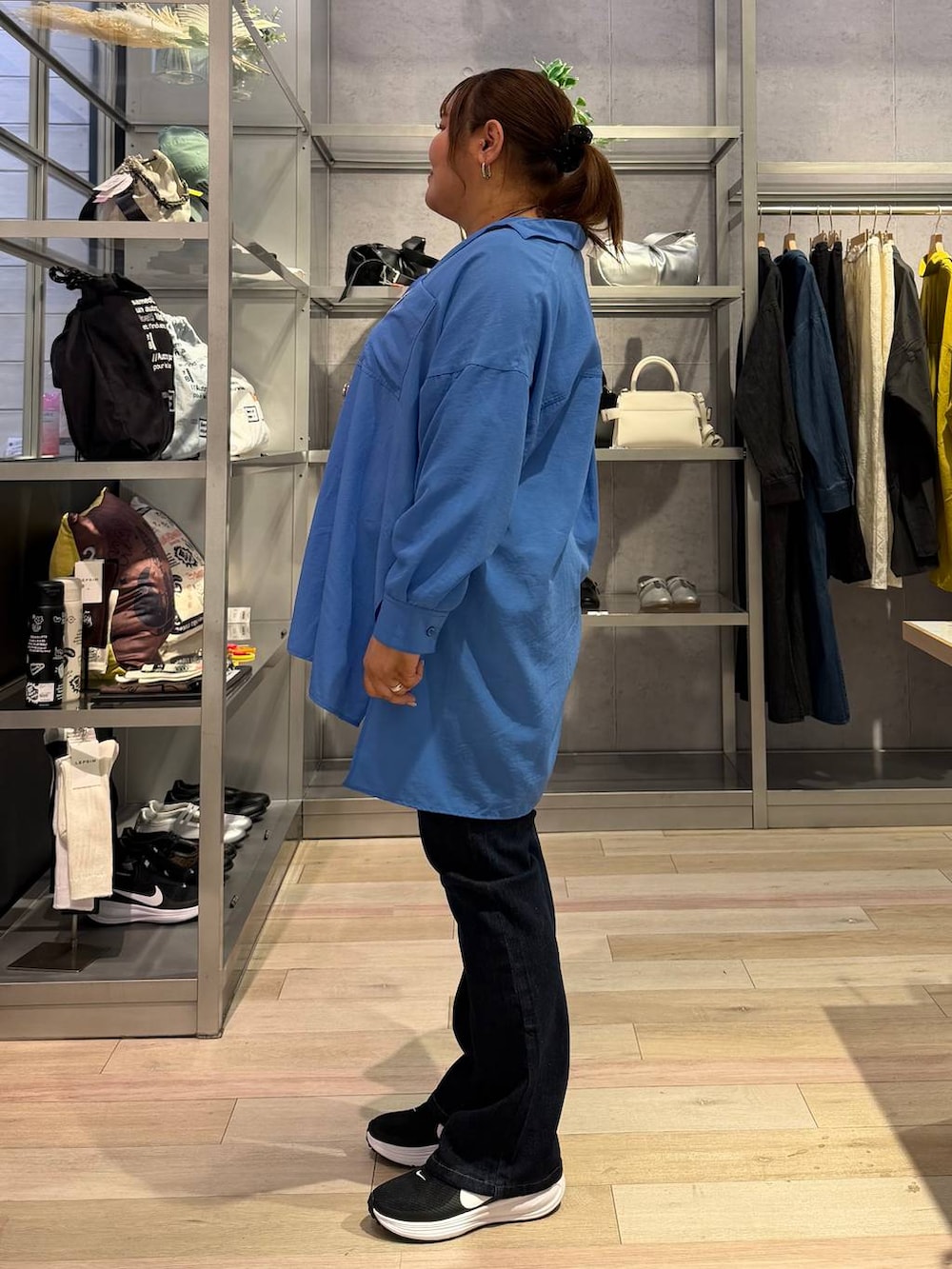 ホワイト系のTシャツ/カットソー、ブルー系のシャツ/ブラウス、グレー系のショルダーバッグを着用したレディースの冬コーディネートの2枚目の写真