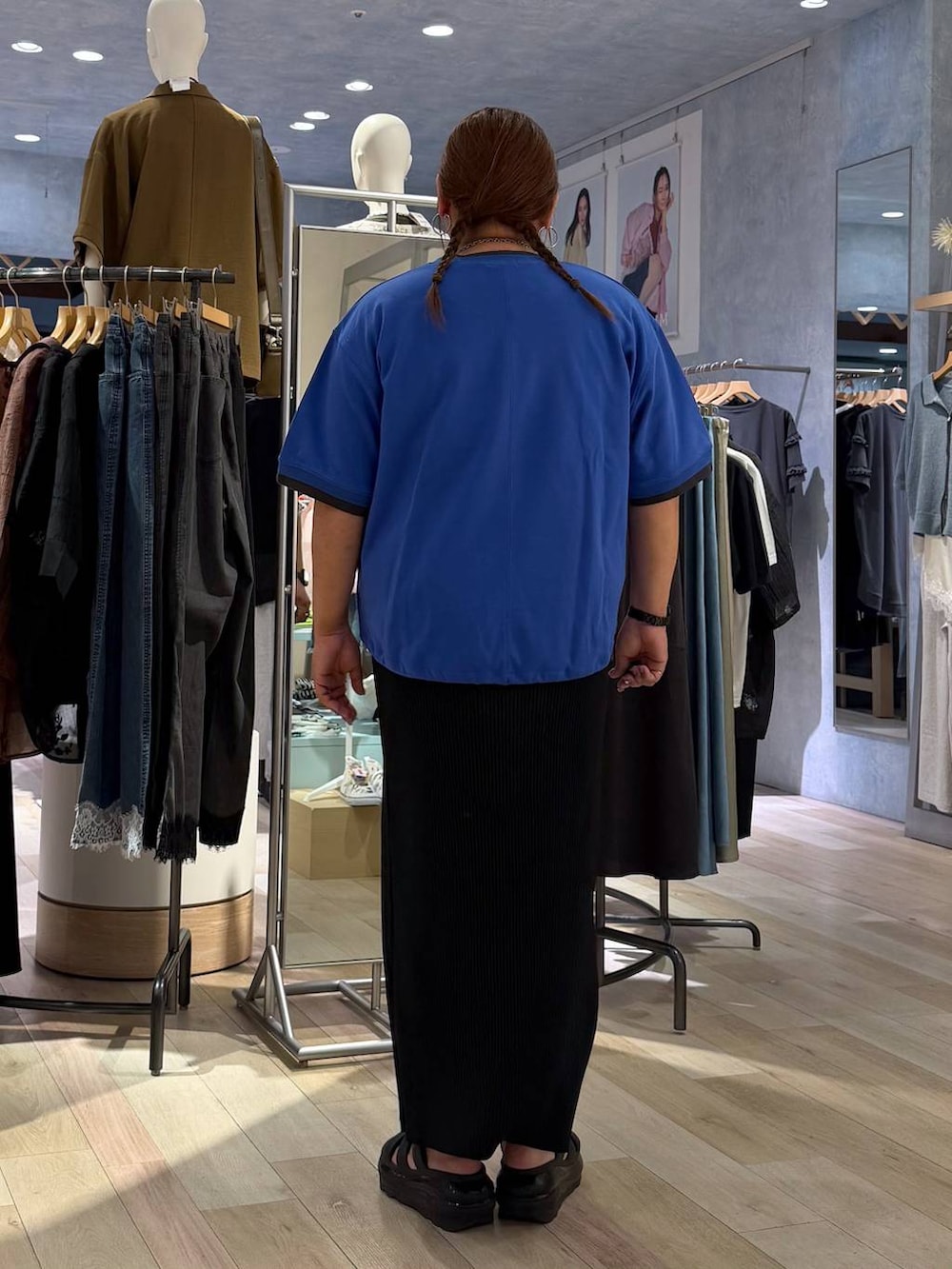 ブラック系のスカート、ブルー系のTシャツ/カットソー、シルバー系のネックレスを着用したレディースの春コーディネートの3枚目の写真