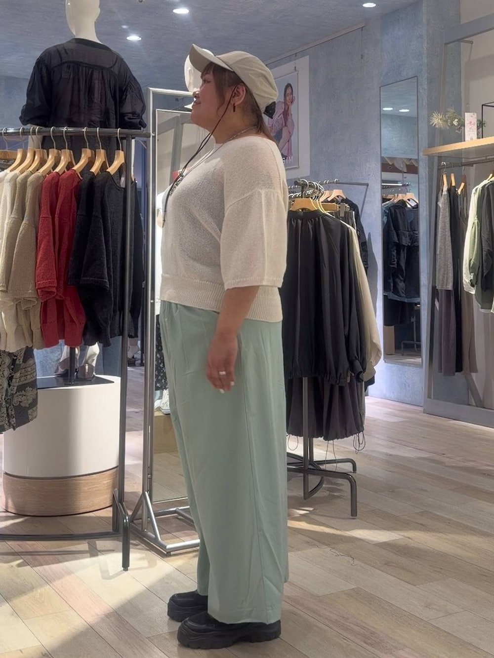 ブラック系のスニーカー、ホワイト系のニット/セーター、グリーン系のその他パンツを着用したレディースの春コーディネートの2枚目の写真