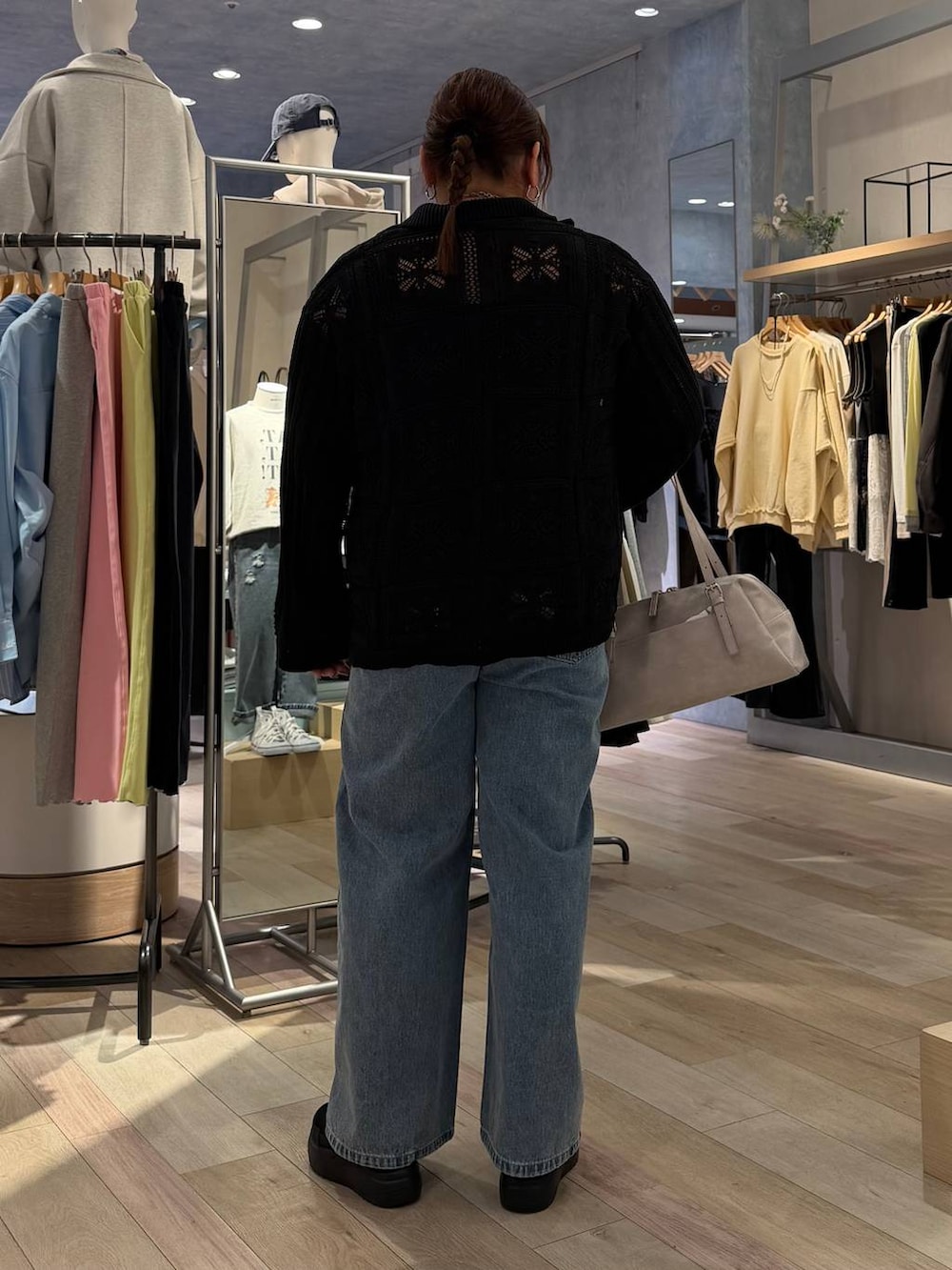 グレー系のボストンバッグ、ブラック系のTシャツ/カットソー、ブルー系のデニムパンツを着用したレディースの冬コーディネートの4枚目の写真