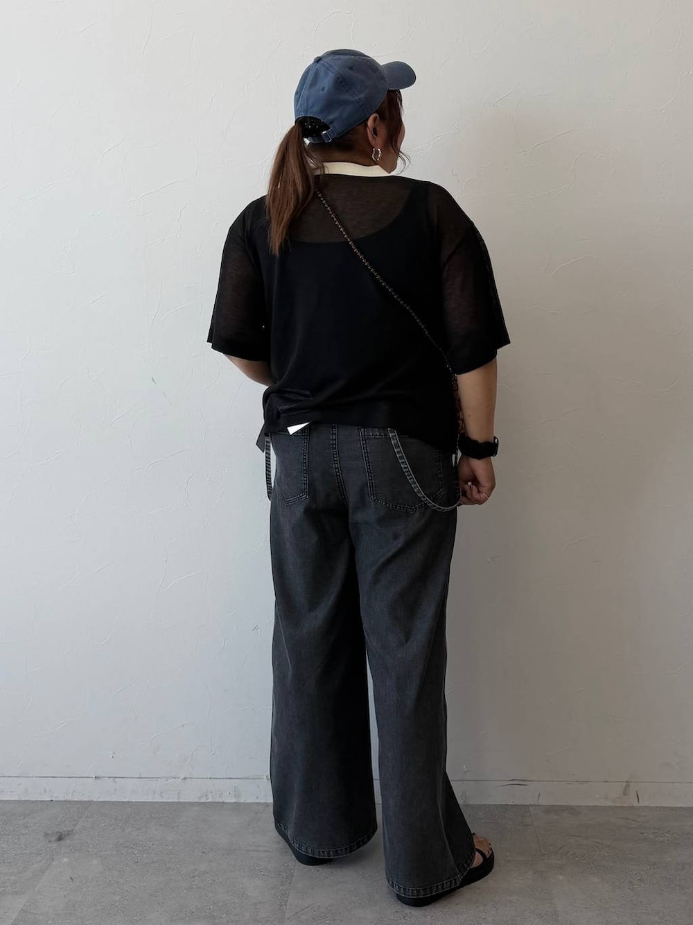 グレー系のサロペット/オーバーオール、ブラック系のサンダル、ブラック系のニット/セーターを着用したレディースの春コーディネートの3枚目の写真