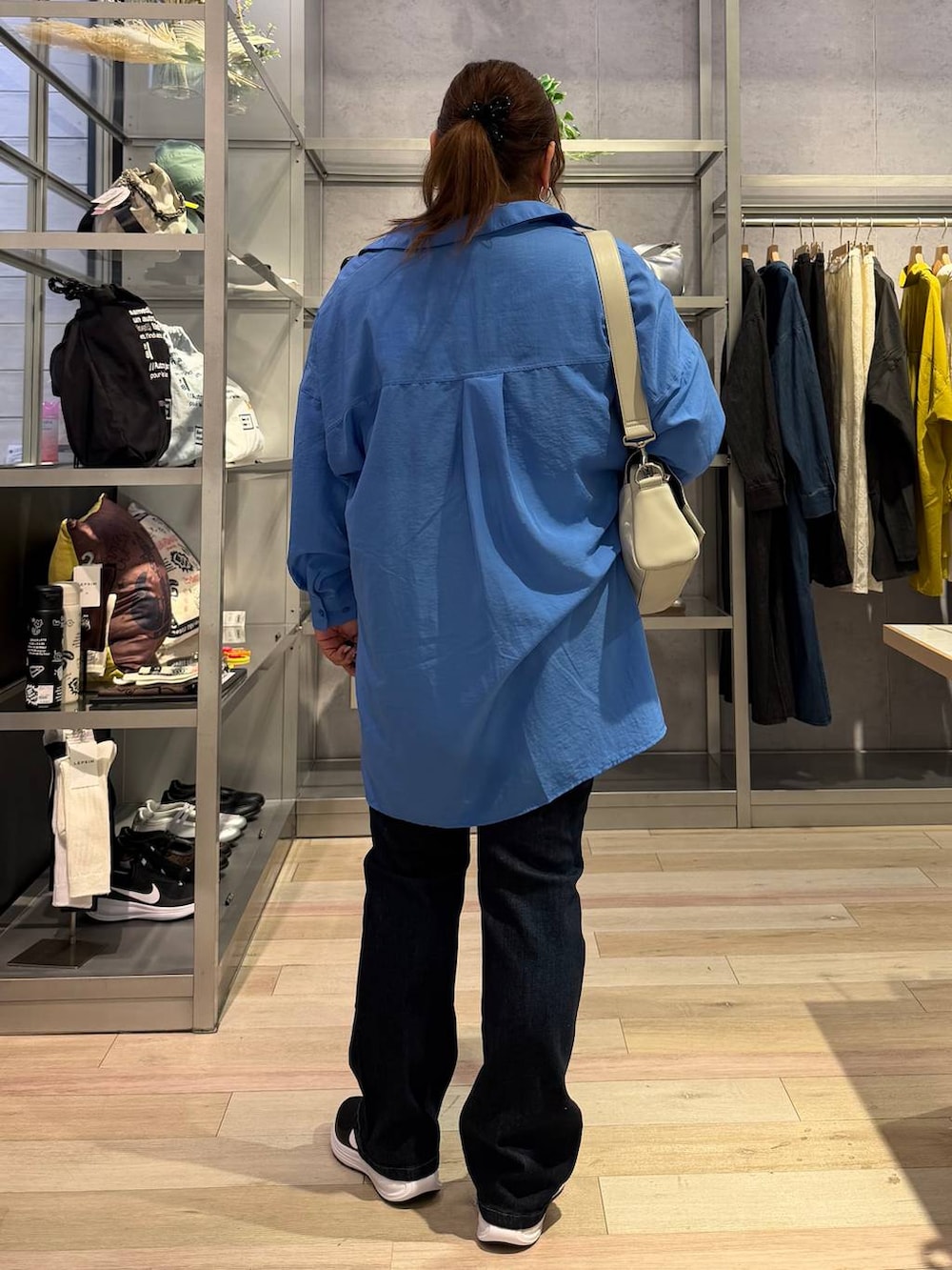 ホワイト系のTシャツ/カットソー、ブルー系のシャツ/ブラウス、グレー系のショルダーバッグを着用したレディースの冬コーディネートの3枚目の写真