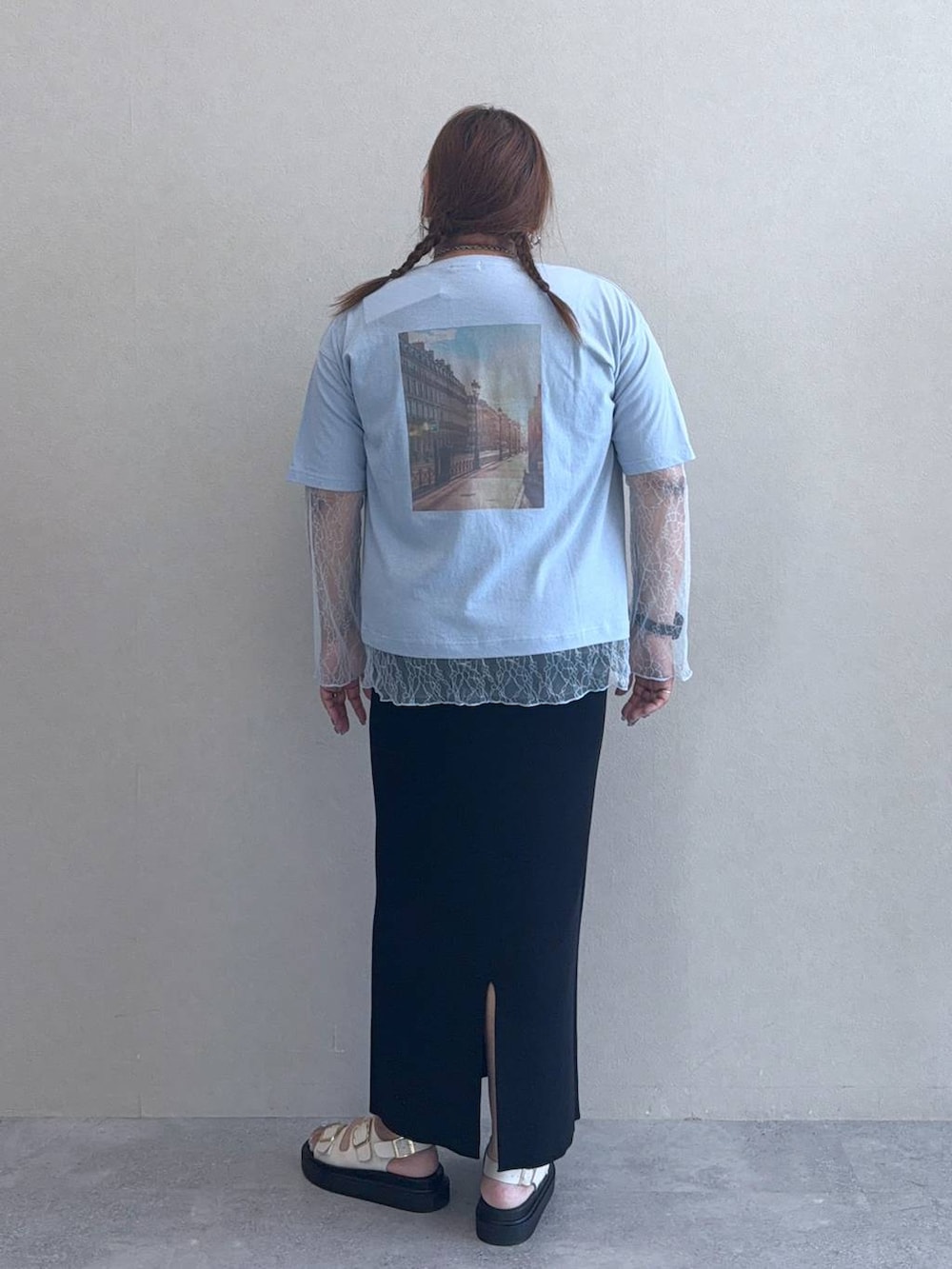 ブラック系のスカート、ホワイト系のサンダル、ブルー系のTシャツ/カットソーを着用したレディースの春コーディネートの3枚目の写真