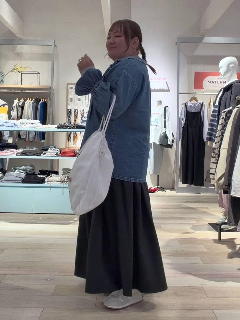 ホワイト系のTシャツ/カットソー、ブラック系のスカート、ホワイト系のスニーカーを着用したレディースの冬コーディネートの2枚目の写真