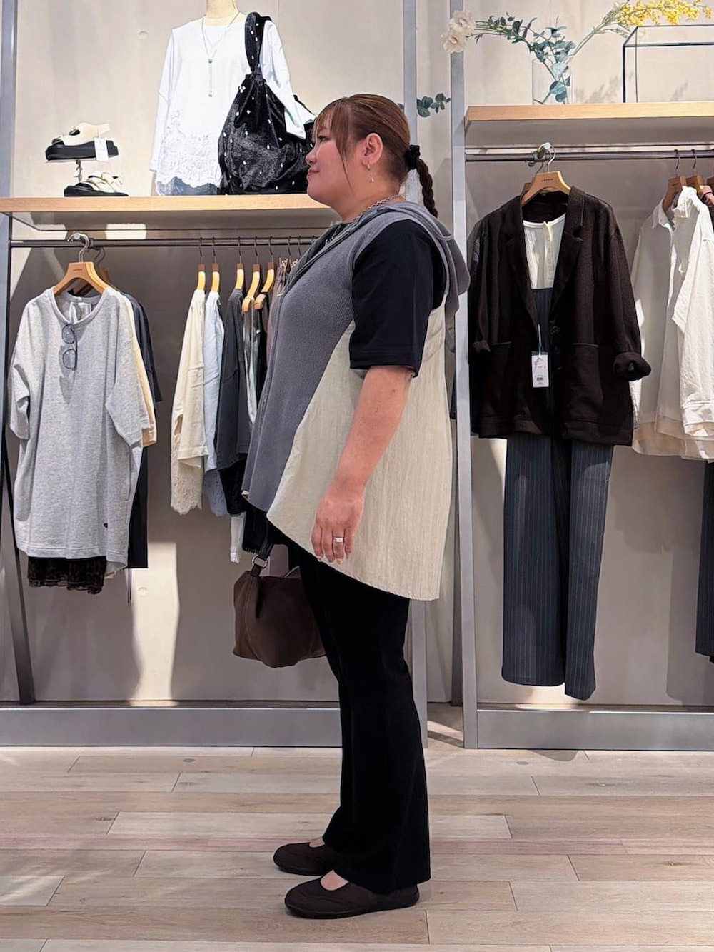 ブラック系のパンプス、ブラウン系のショルダーバッグ、グレー系のその他トップスを着用したレディースの夏コーディネートの2枚目の写真