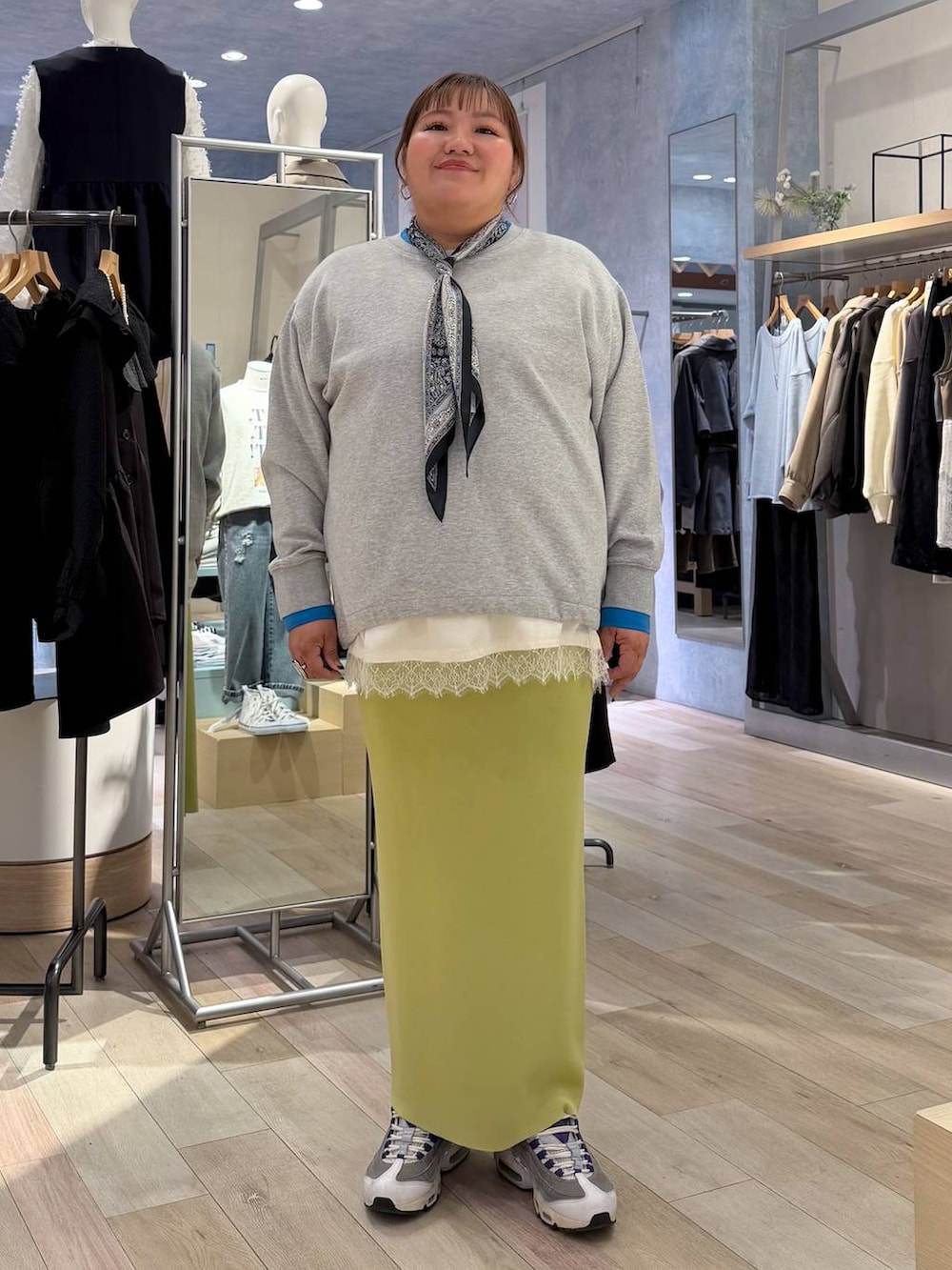 グリーン系のスカート、ホワイト系のキャミソール、ベージュ系のTシャツ/カットソーを着用したレディースの冬コーディネートの2枚目の写真