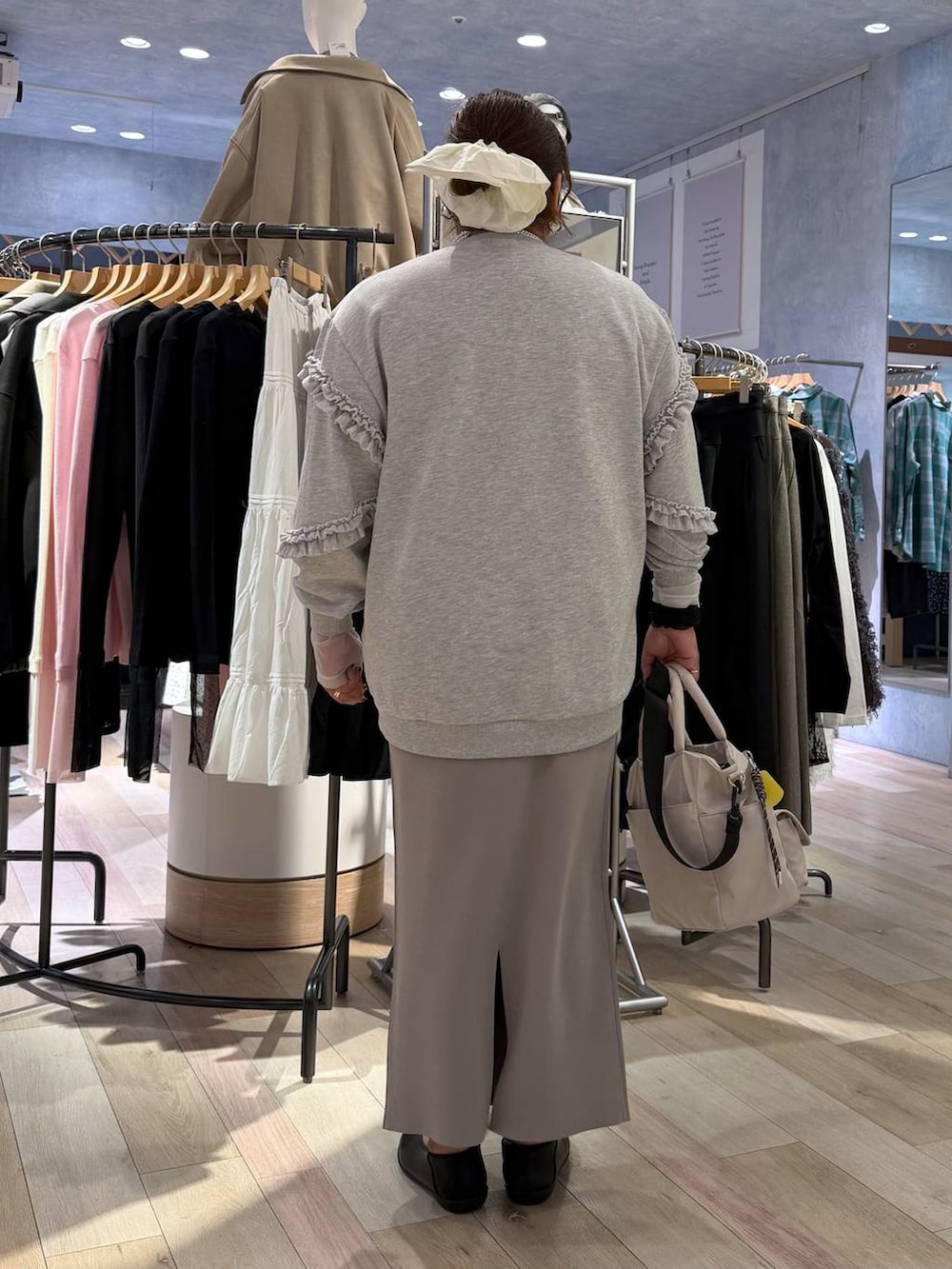 グレー系のスカート、ホワイト系のトートバッグ、ブラック系のパンプスを着用したレディースの冬コーディネートの3枚目の写真