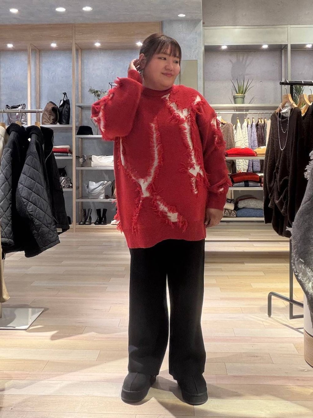 ブラック系のその他パンツ、レッド系のニット/セーター、ブラック系のその他シューズを着用したレディースの冬コーディネートの4枚目の写真