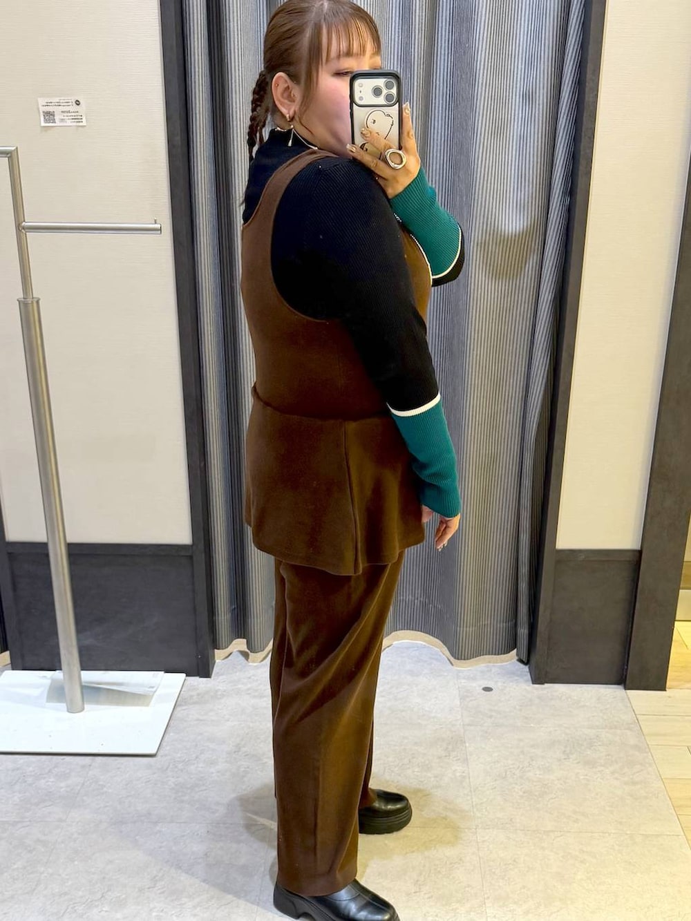 ブラック系のニット/セーター、ブラック系のブーツ、イエロー系のつなぎ/オールインワンを着用したレディースの冬コーディネートの4枚目の写真