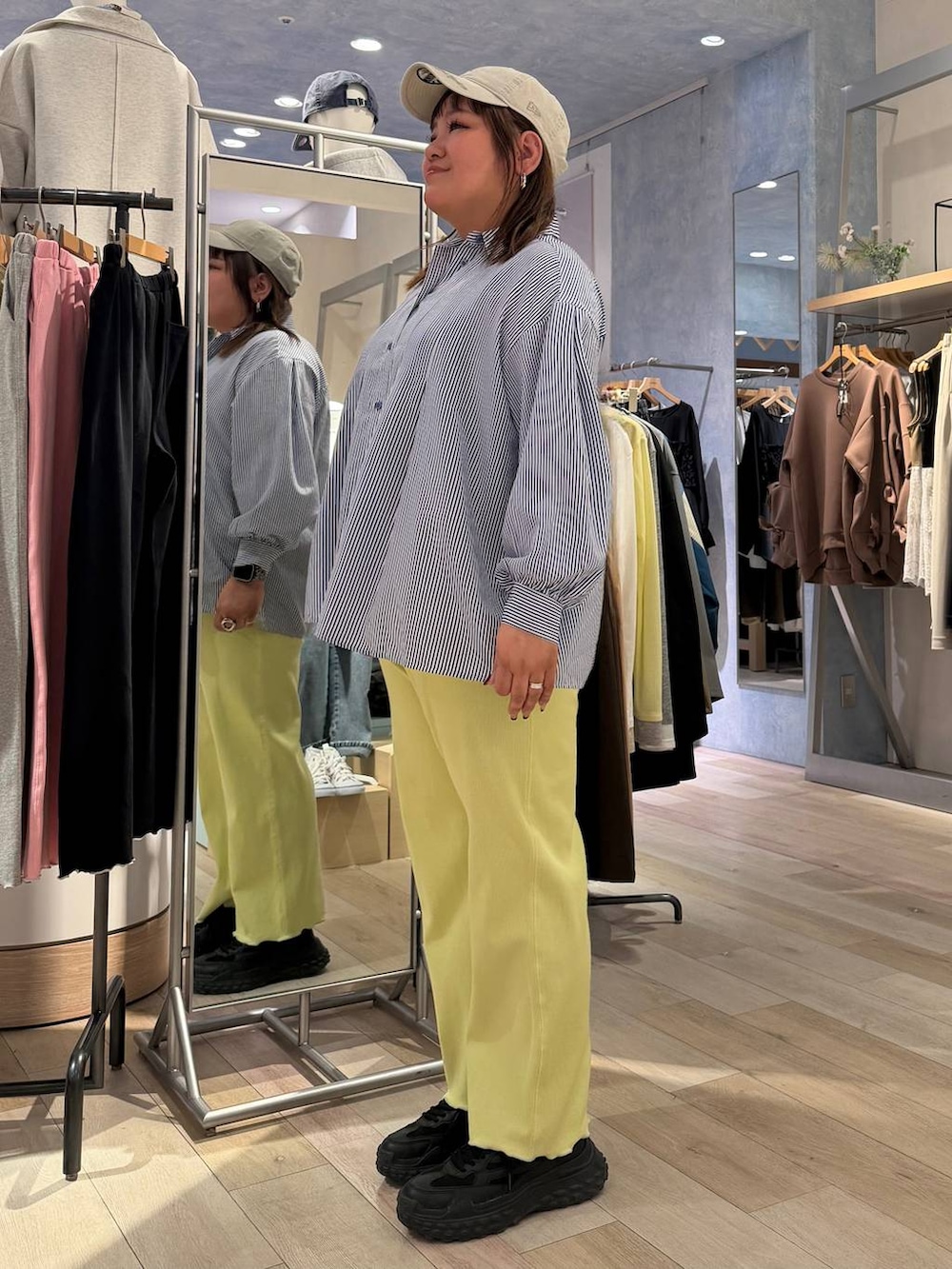 ブルー系のシャツ/ブラウス、グレー系のキャップを着用したレディースの冬コーディネートの2枚目の写真