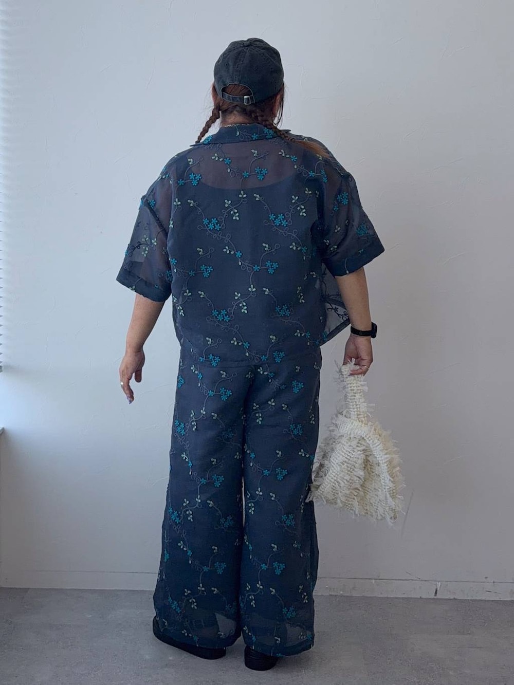 ブラック系のサンダル、ブルー系のその他パンツ、ホワイト系のハンドバッグを着用したレディースの春コーディネートの3枚目の写真