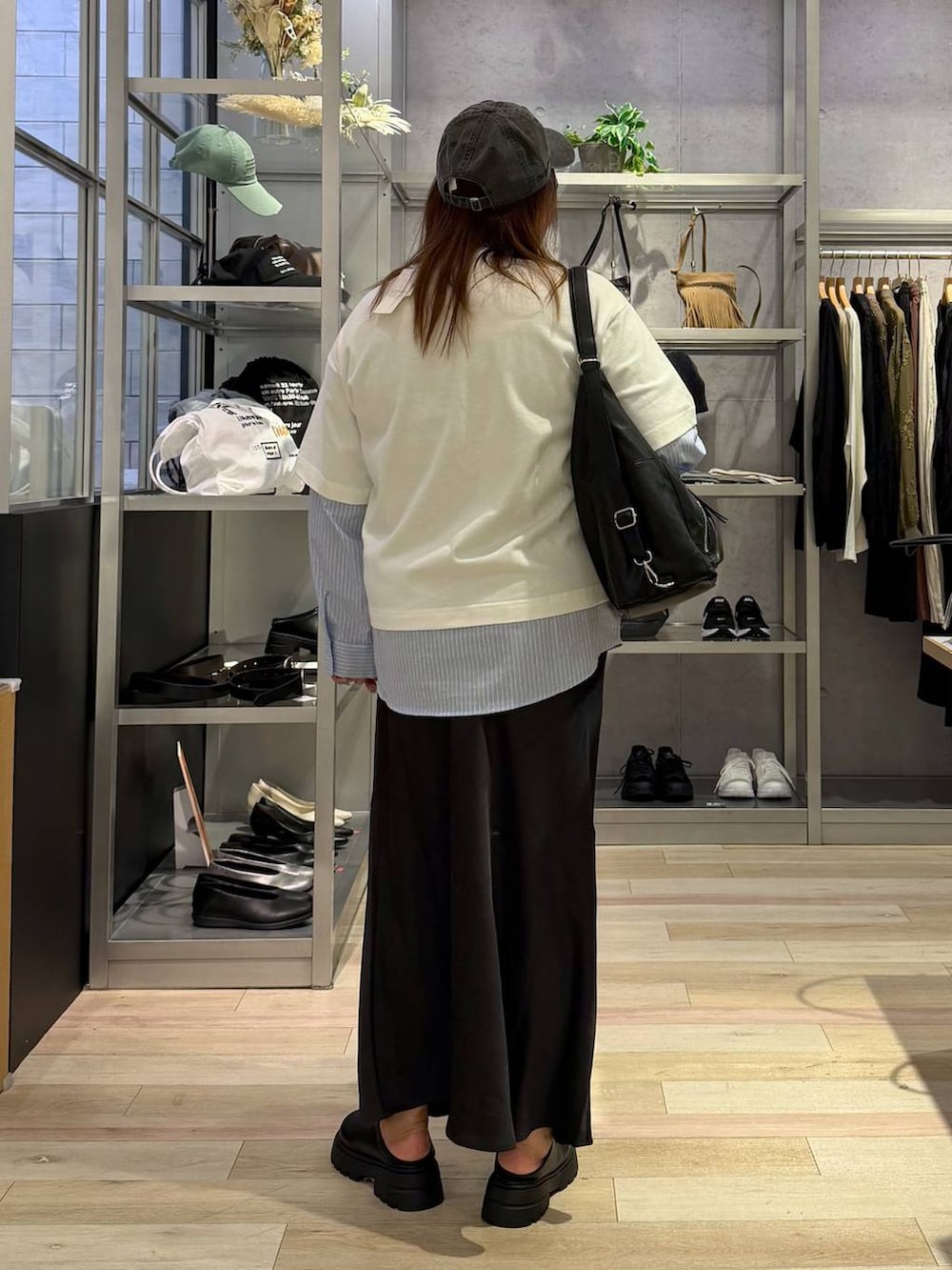 グレー系のショルダーバッグ、ブラック系のその他シューズ、ホワイト系のTシャツ/カットソーを着用したレディースの春コーディネートの3枚目の写真