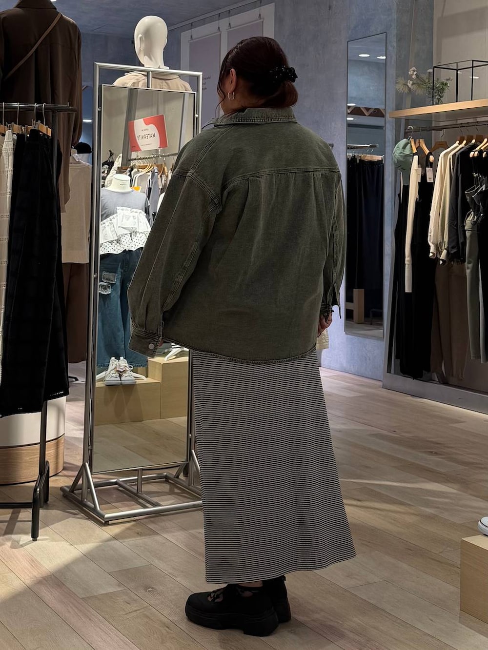 ブラック系のその他シューズ、ホワイト系のスカート、グリーン系のシャツ/ブラウスを着用したレディースの春コーディネートの3枚目の写真