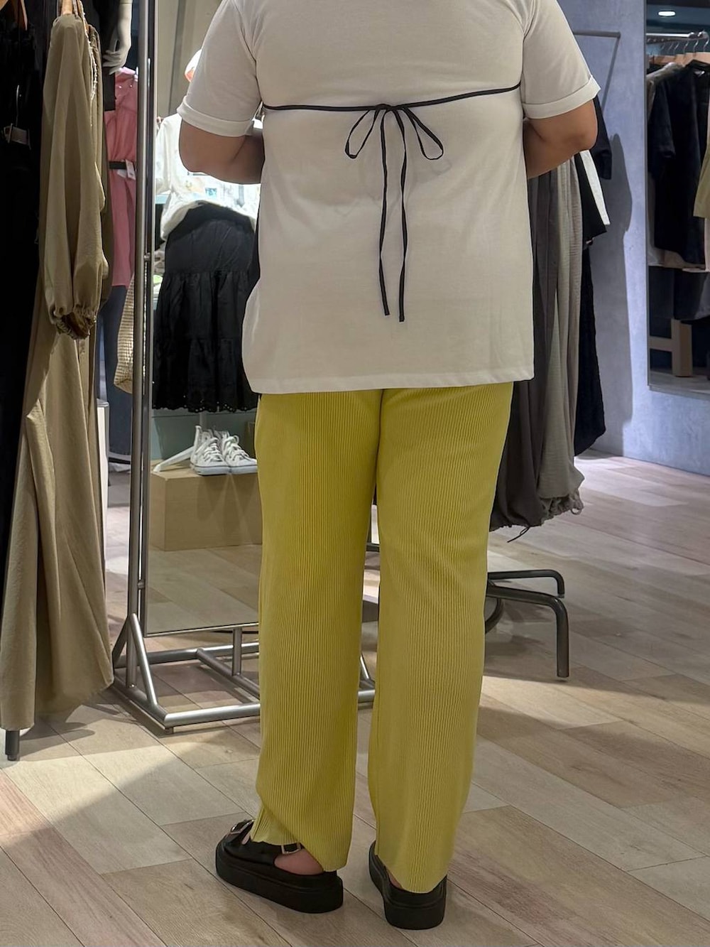 イエロー系のその他パンツ、ブラック系のサンダル、ホワイト系のTシャツ/カットソーを着用したレディースの春コーディネートの3枚目の写真