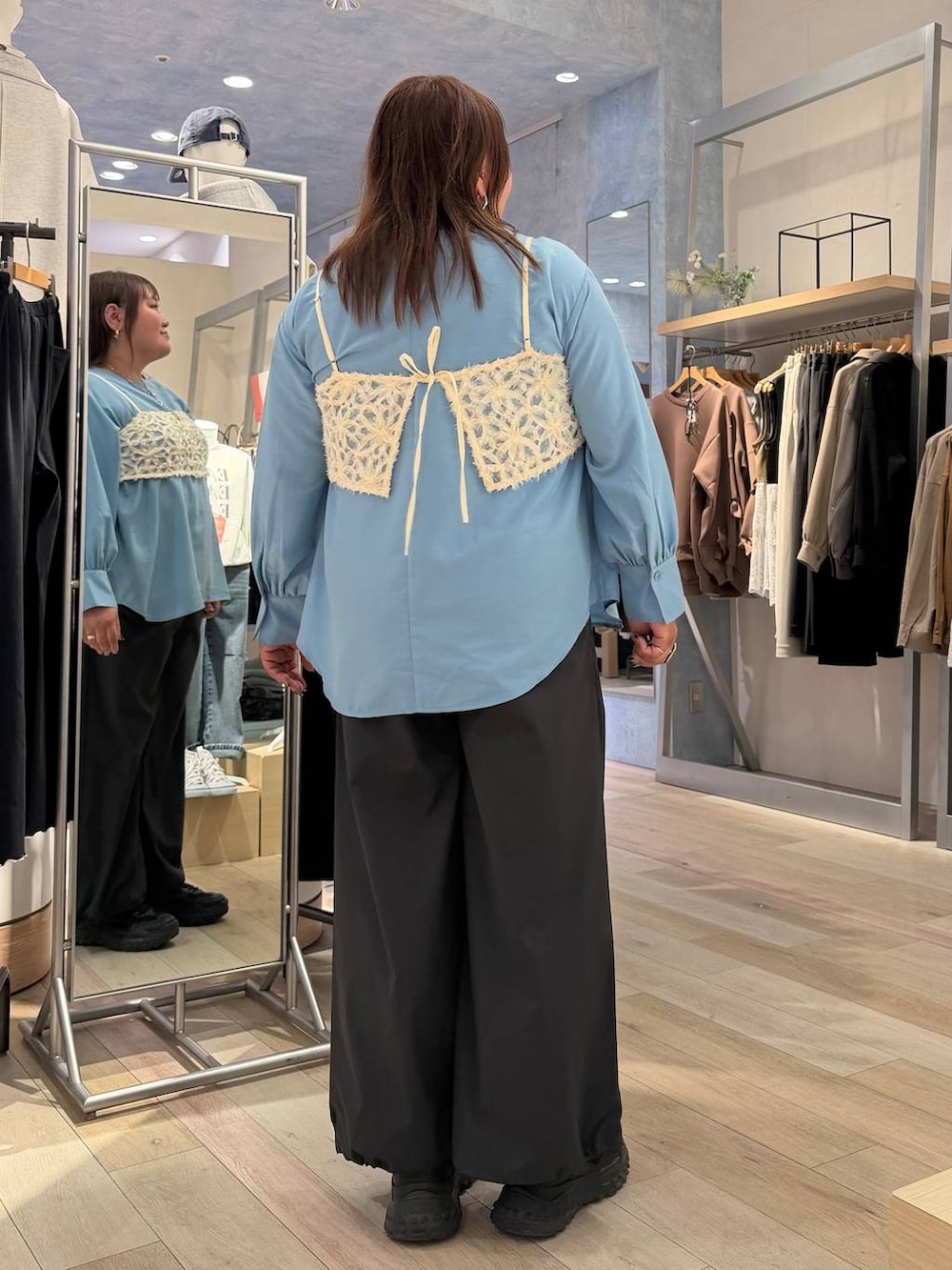 グレー系のその他パンツ、ブルー系のシャツ/ブラウス、シルバー系のネックレスを着用したレディースの冬コーディネートの3枚目の写真