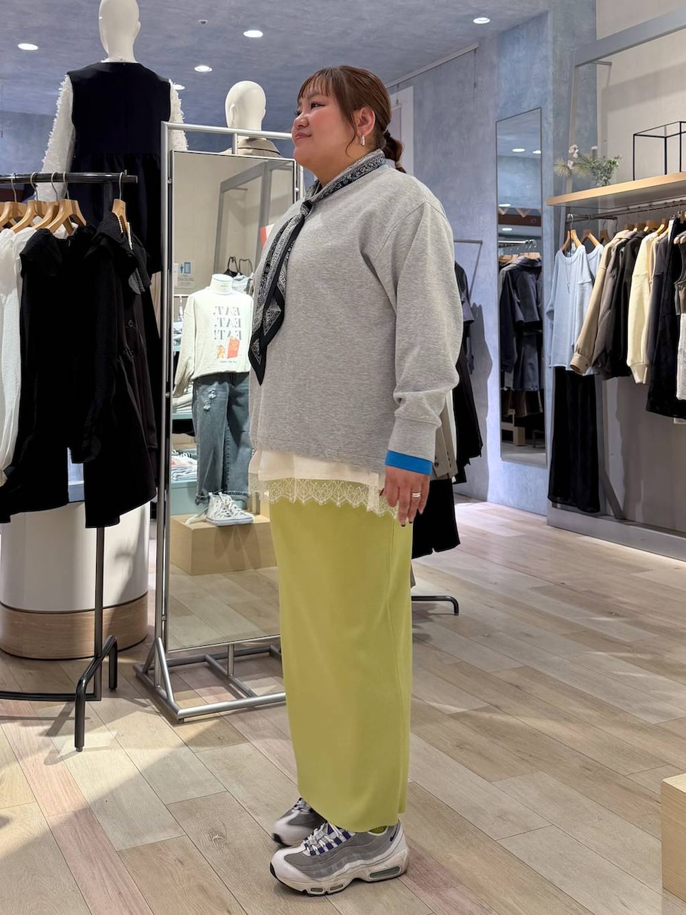 グリーン系のスカート、ホワイト系のキャミソール、ベージュ系のTシャツ/カットソーを着用したレディースの冬コーディネートの3枚目の写真