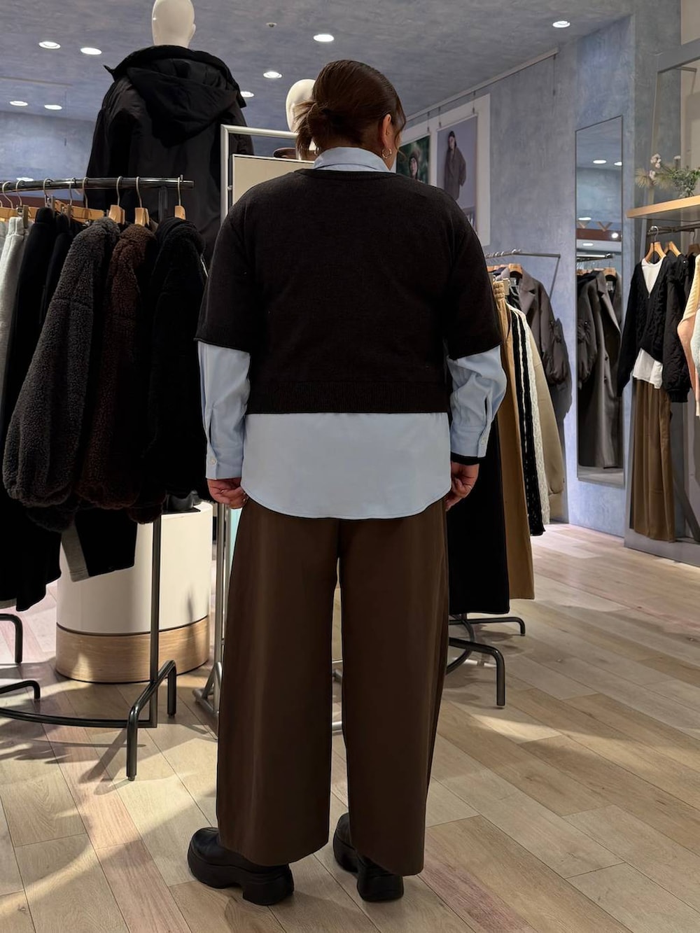 ブラック系のブーツ、ブラック系のニット/セーター、ブラウン系のその他パンツを着用したレディースの冬コーディネートの2枚目の写真