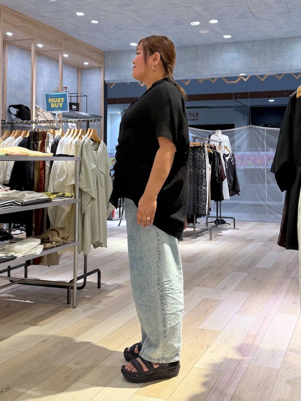 ブルー系のデニムパンツ、ブラック系のシャツ/ブラウス、シルバー系のネックレスを着用したレディースの春コーディネートの2枚目の写真