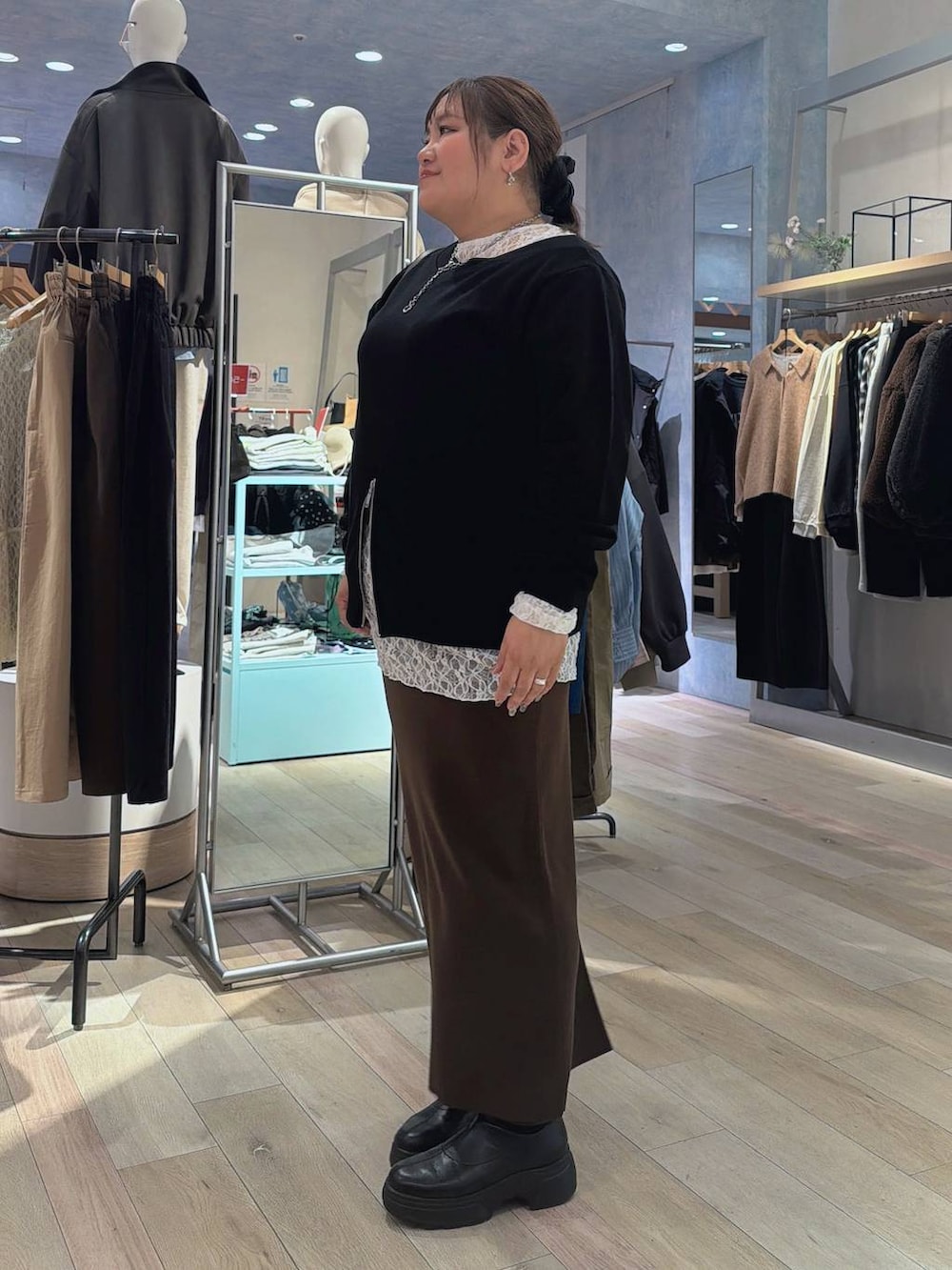 ブラウン系のスカート、ブラウン系のショルダーバッグ、ブラック系のTシャツ/カットソーを着用したレディースの冬コーディネートの3枚目の写真