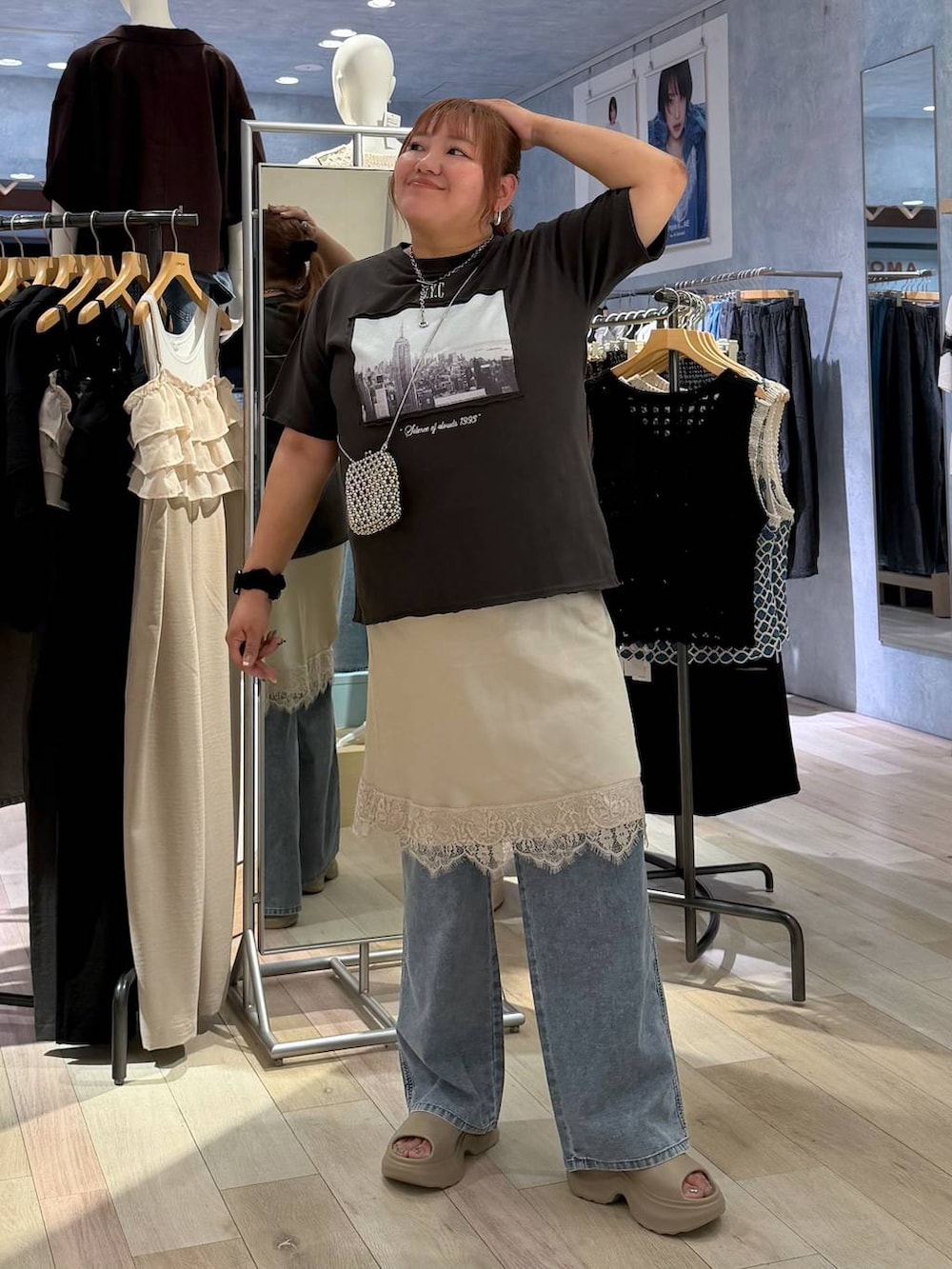 ブルー系のデニムパンツ、グレー系のTシャツ/カットソー、ベージュ系のサンダルを着用したレディースの夏コーディネートの4枚目の写真