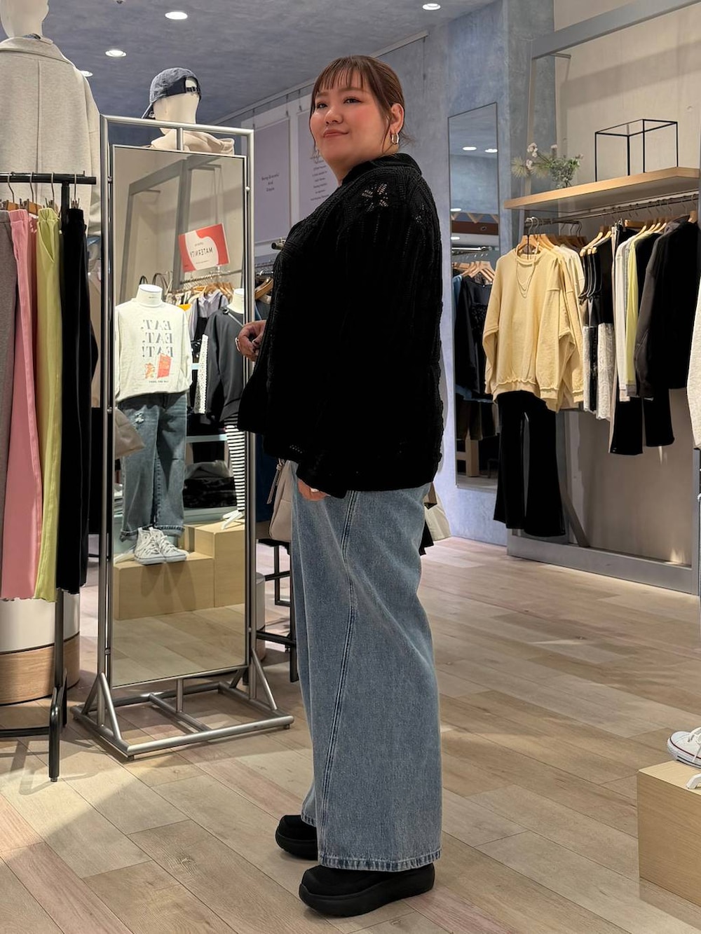 グレー系のボストンバッグ、ブラック系のTシャツ/カットソー、ブルー系のデニムパンツを着用したレディースの冬コーディネートの2枚目の写真