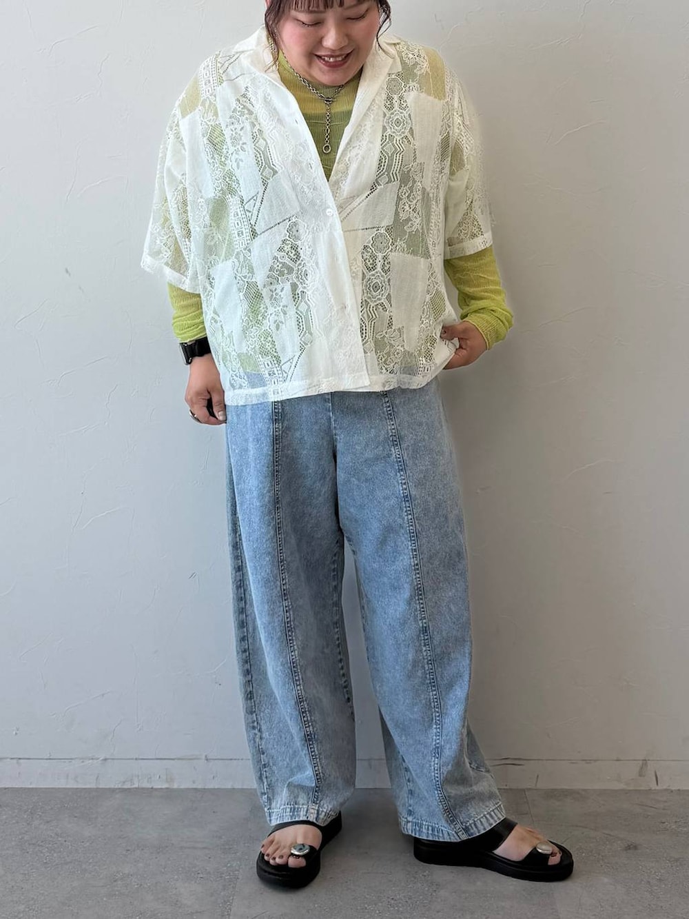 ブラック系のサンダル、ブルー系のデニムパンツ、シルバー系のネックレスを着用したレディースの春コーディネートの4枚目の写真