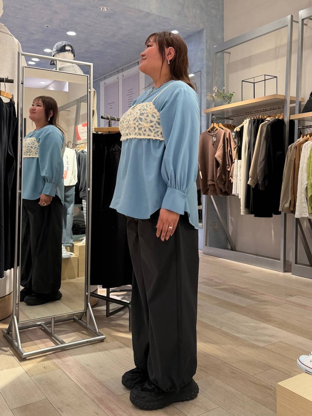 グレー系のその他パンツ、ブルー系のシャツ/ブラウス、シルバー系のネックレスを着用したレディースの冬コーディネートの2枚目の写真