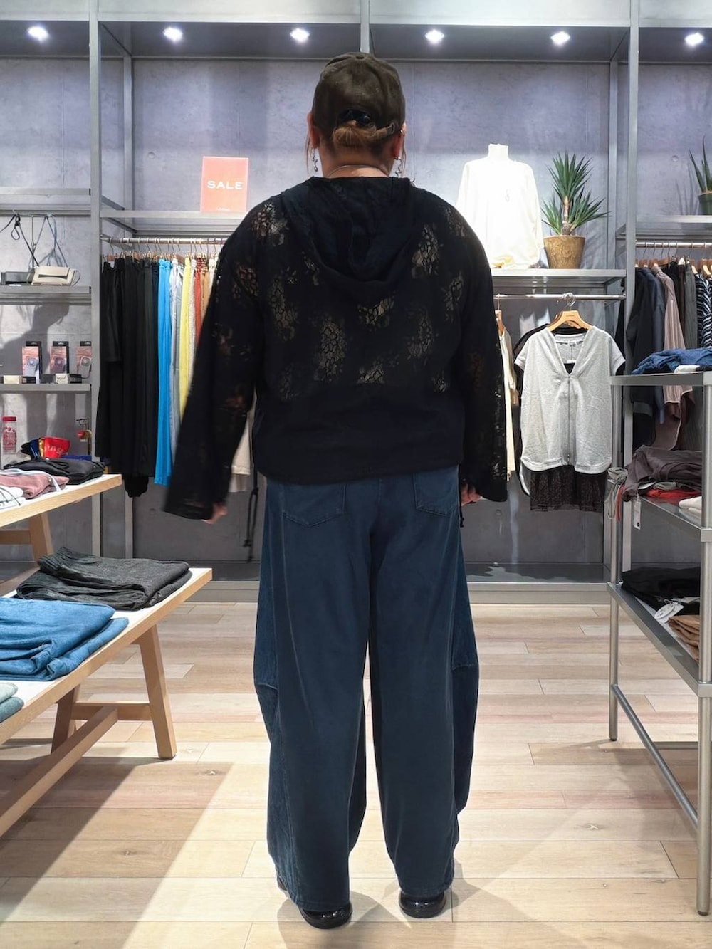 ブルー系のデニムパンツ、ブラック系のその他トップス、ブラウン系のキャップを着用したレディースの秋コーディネートの3枚目の写真