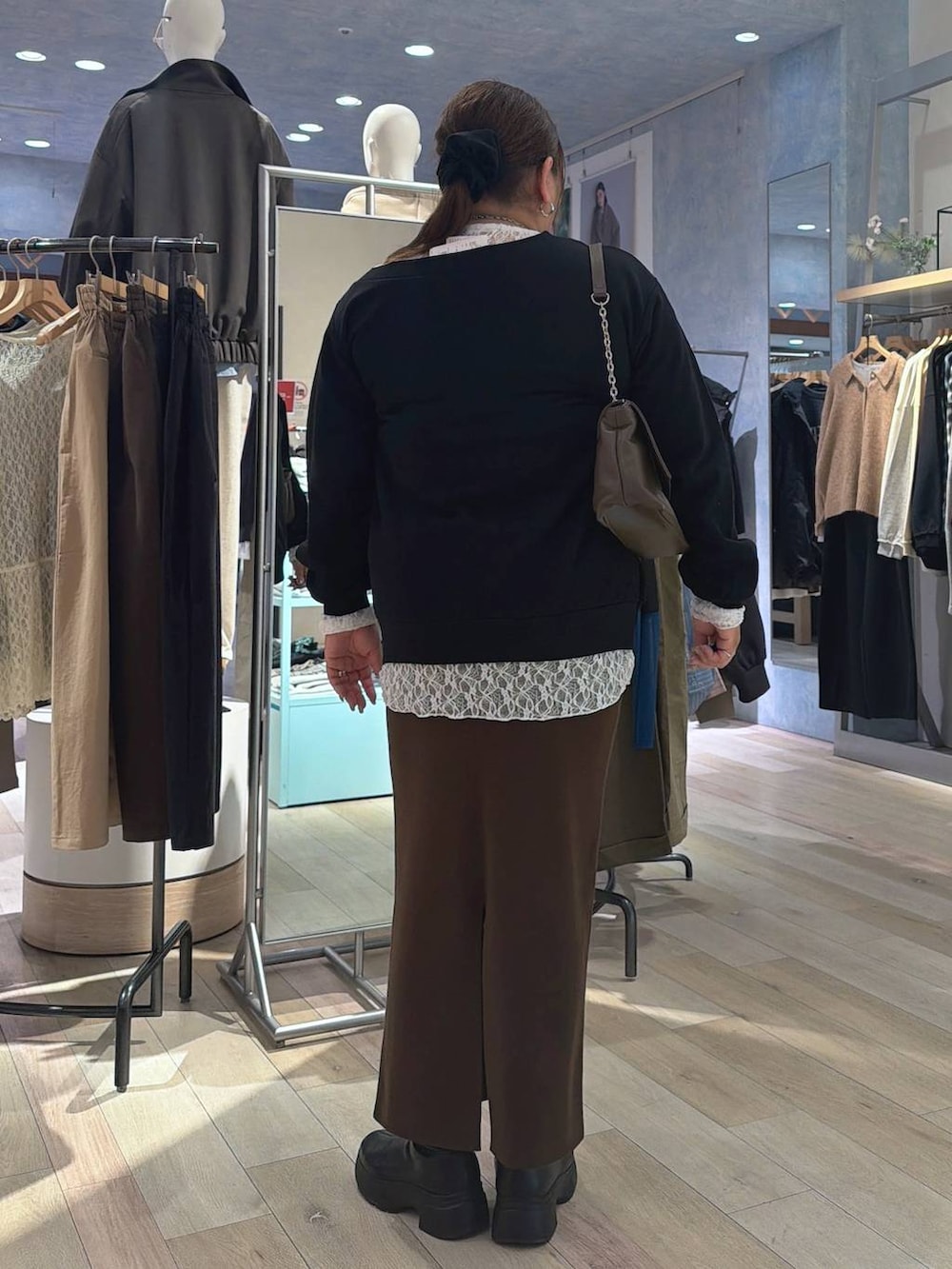 ブラウン系のスカート、ブラウン系のショルダーバッグ、ブラック系のTシャツ/カットソーを着用したレディースの冬コーディネートの4枚目の写真