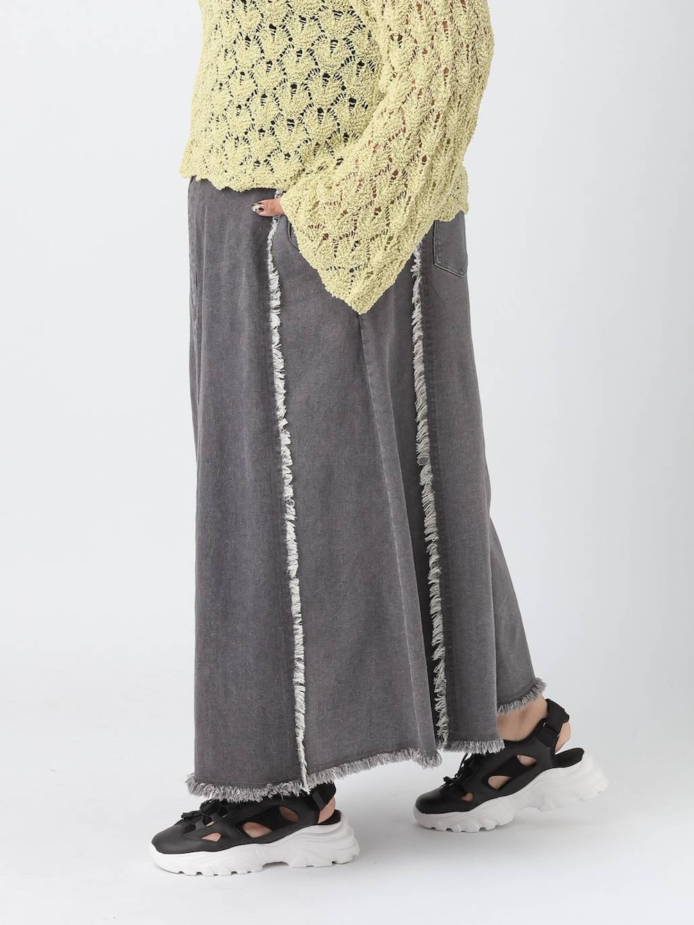 ブラック系のタンクトップ、ブラック系のサンダル、グリーン系のニット/セーターを着用したレディースの春コーディネートの3枚目の写真