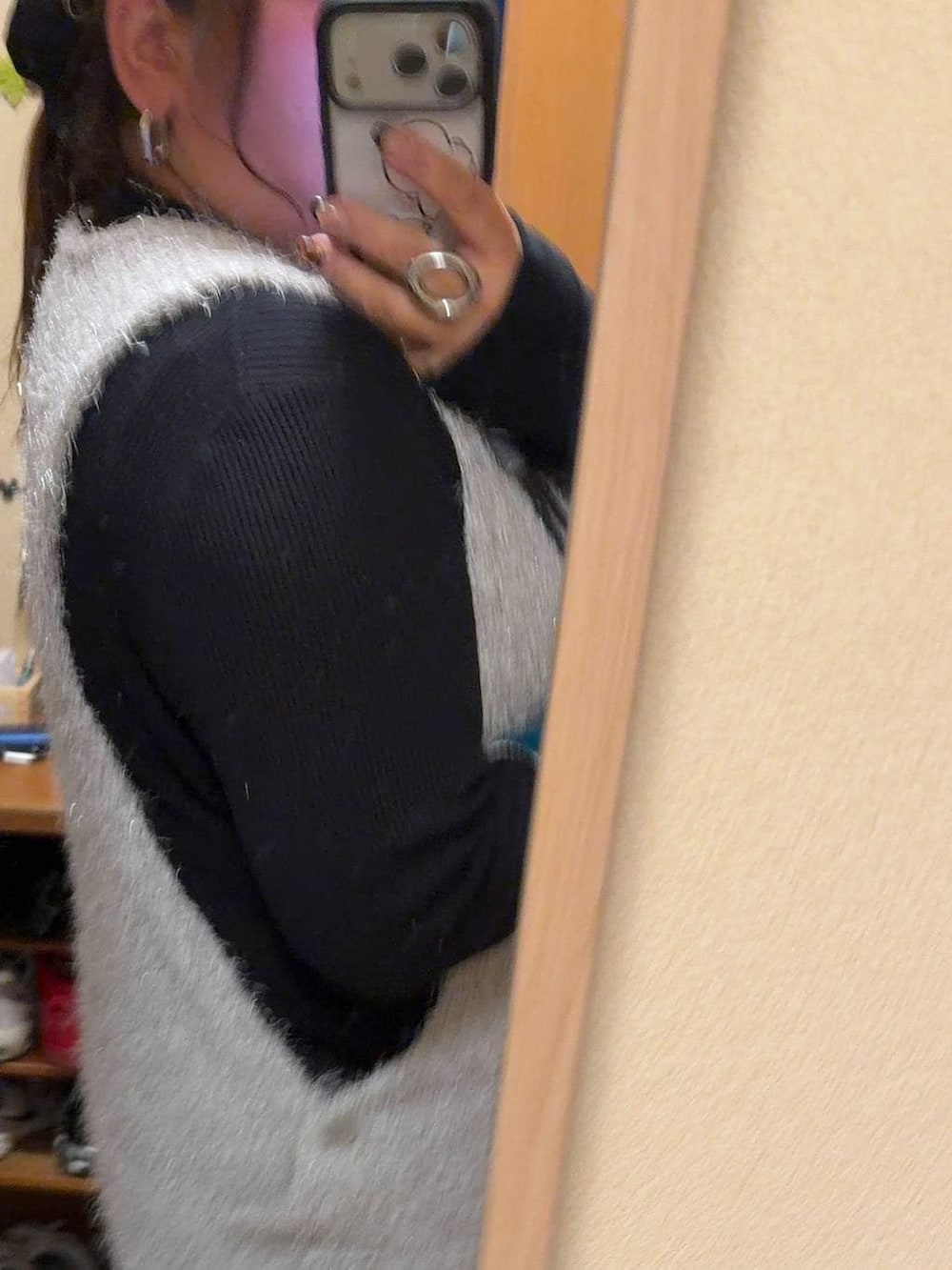 ブラック系のニット/セーター、グレー系のベスト、ブラック系のシュシュを着用したレディースの冬コーディネートの2枚目の写真