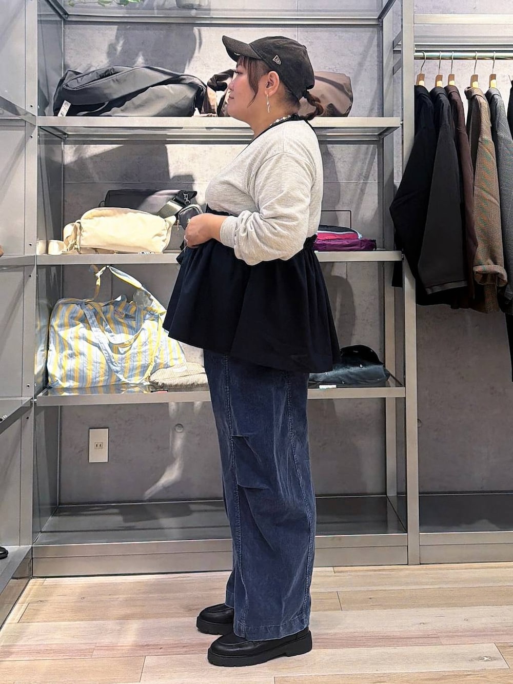 ブルー系のその他パンツ、ブラウン系のキャップ、シルバー系のネックレスを着用したレディースの秋コーディネートの2枚目の写真