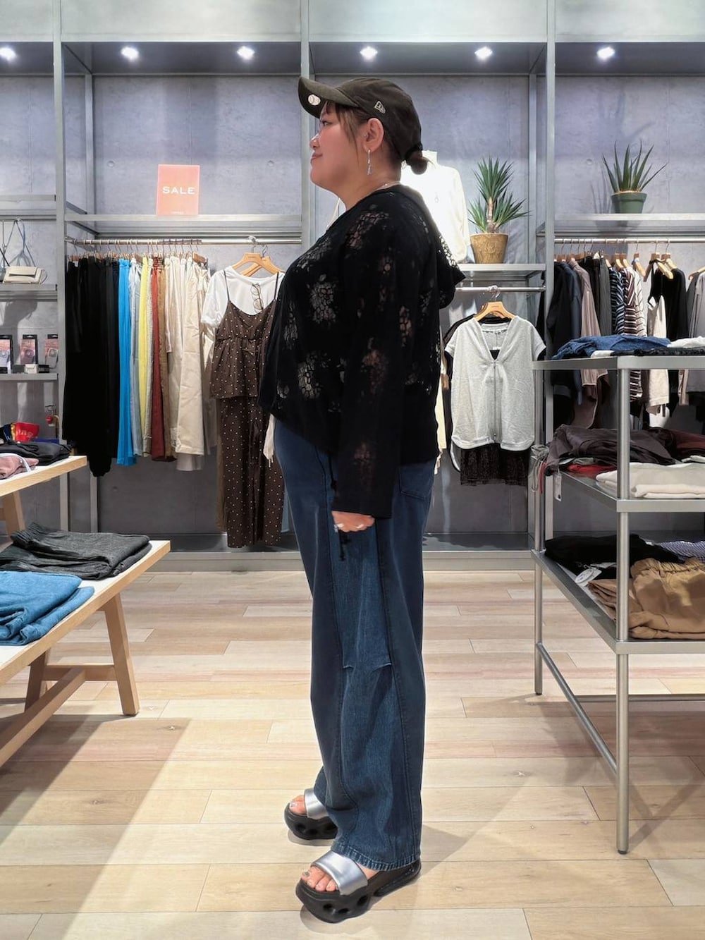 ブルー系のデニムパンツ、ブラック系のその他トップス、ブラウン系のキャップを着用したレディースの秋コーディネートの2枚目の写真