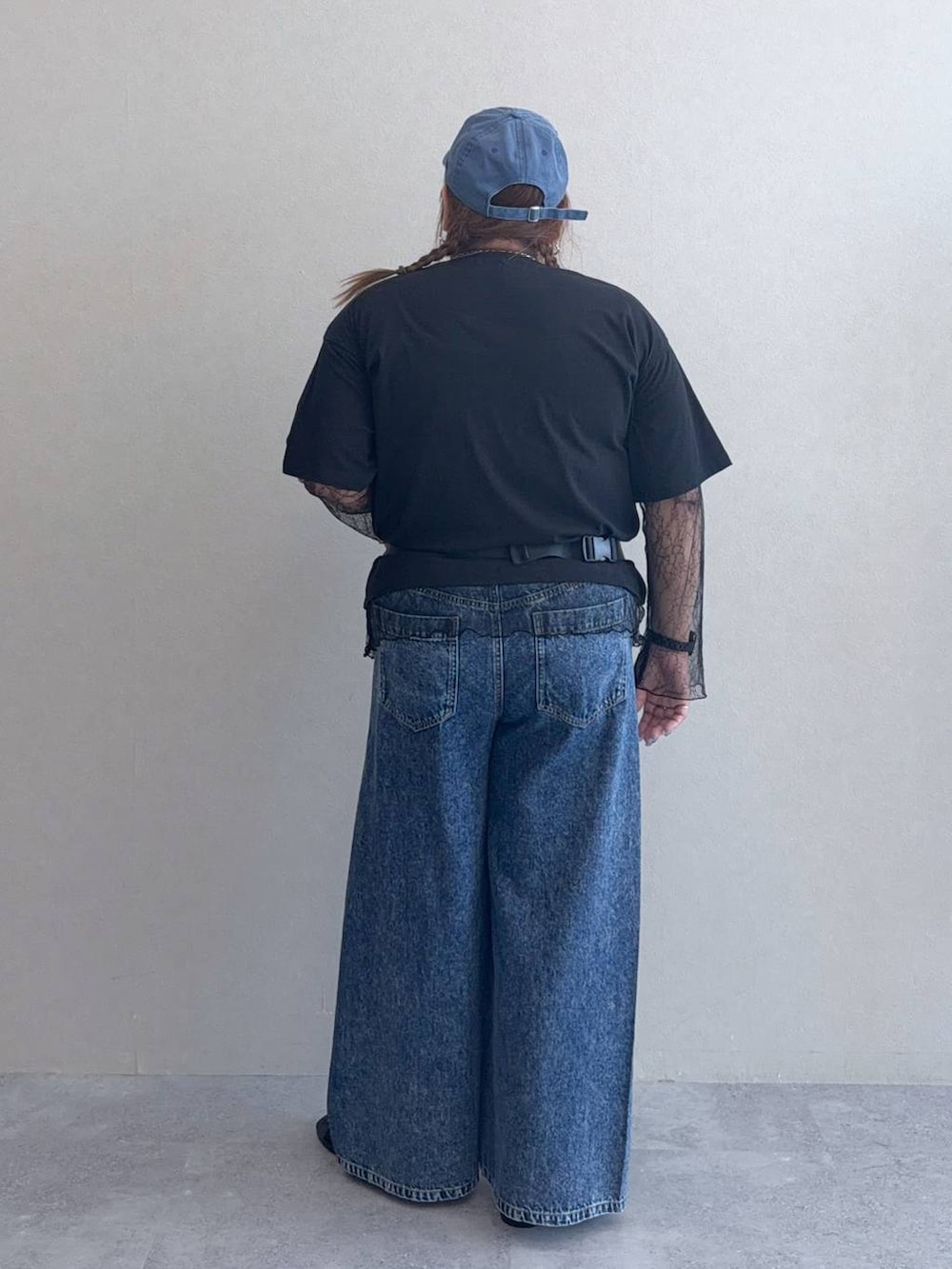 ブルー系のデニムパンツ、ブラック系のボディバッグ/ウエストポーチ、ブラック系のサンダルを着用したレディースの春コーディネートの3枚目の写真