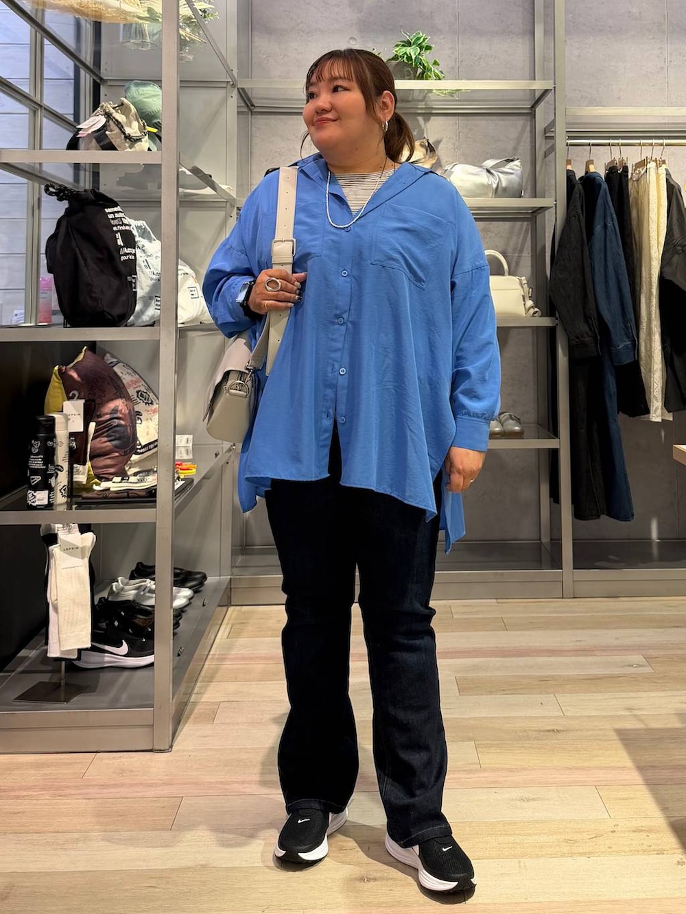 ホワイト系のTシャツ/カットソー、ブルー系のシャツ/ブラウス、グレー系のショルダーバッグを着用したレディースの冬コーディネートの4枚目の写真