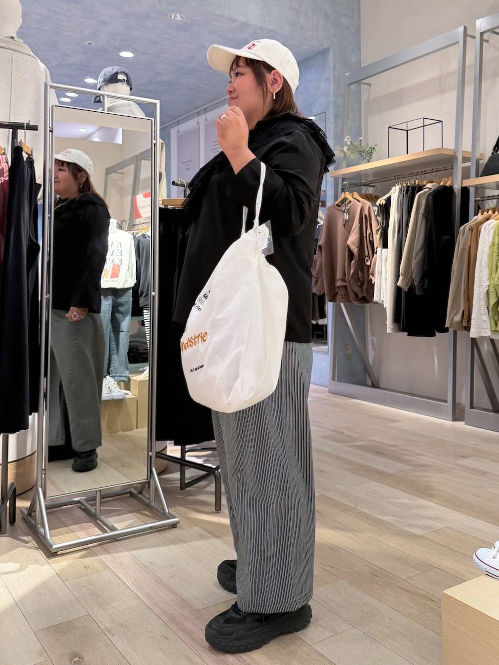 ブルー系のその他パンツ、ブラック系のシャツ/ブラウス、ホワイト系のトートバッグを着用したレディースの冬コーディネートの2枚目の写真