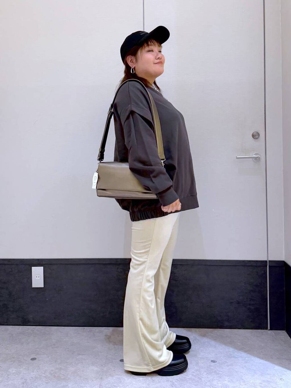 ホワイト系のその他パンツ、その他のショルダーバッグ、グレー系のTシャツ/カットソーを着用したレディースの秋コーディネートの2枚目の写真