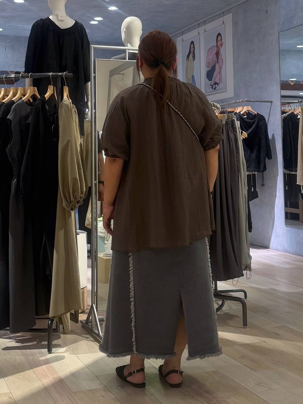 シルバー系のショルダーバッグ、ブラック系のパンプス、ブラウン系のシャツ/ブラウスを着用したレディースの春コーディネートの3枚目の写真