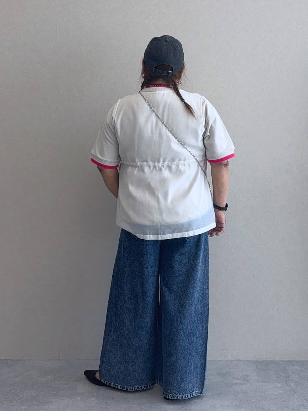 ブルー系のデニムパンツ、シルバー系のショルダーバッグ、ブラック系のパンプスを着用したレディースの夏コーディネートの3枚目の写真