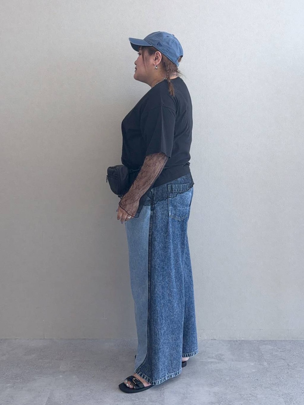ブルー系のデニムパンツ、ブラック系のボディバッグ/ウエストポーチ、ブラック系のサンダルを着用したレディースの春コーディネートの2枚目の写真