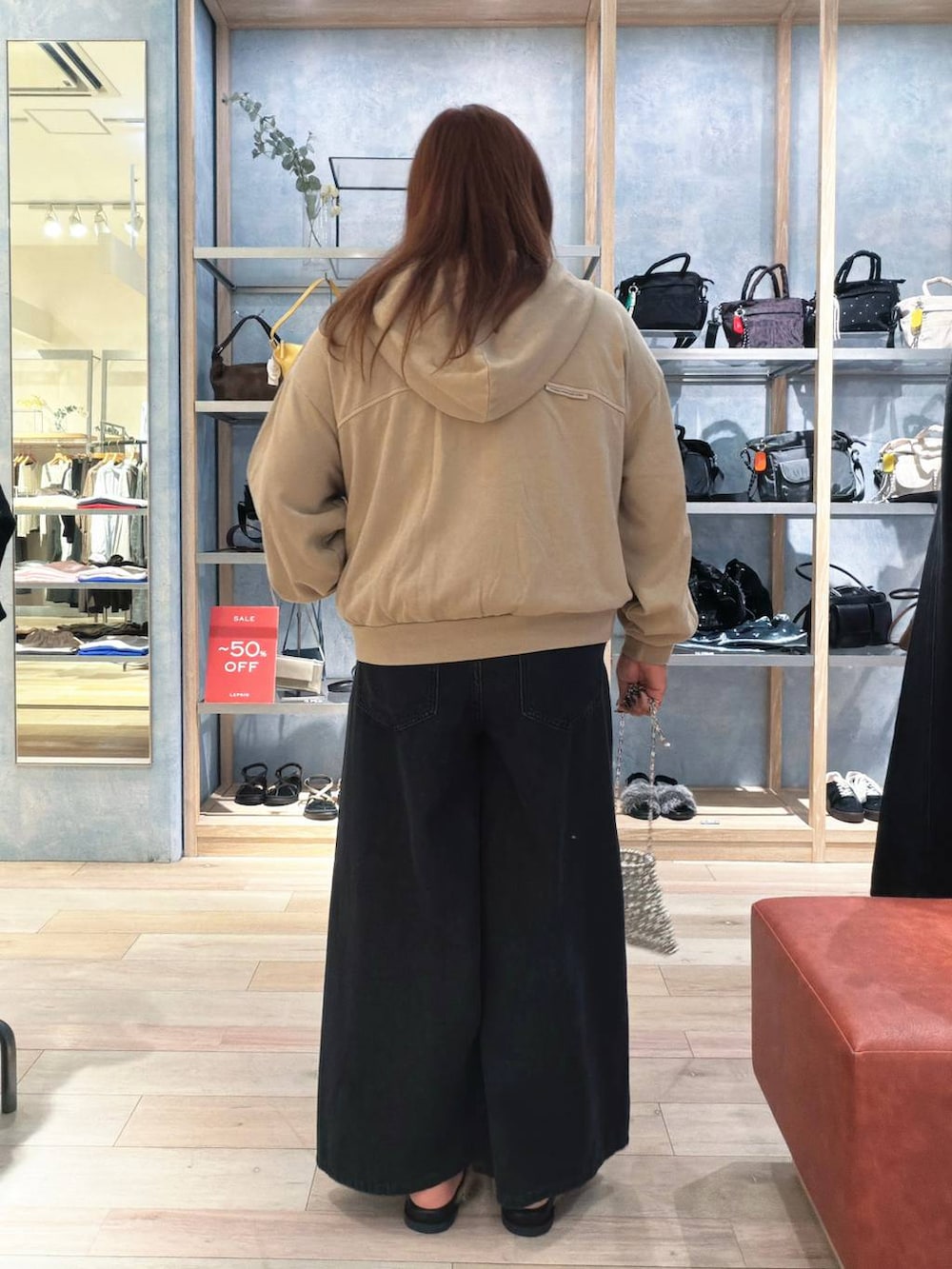ブラウン系のサンダル、ベージュ系のパーカー、ブラック系のデニムパンツを着用したレディースの夏コーディネートの3枚目の写真