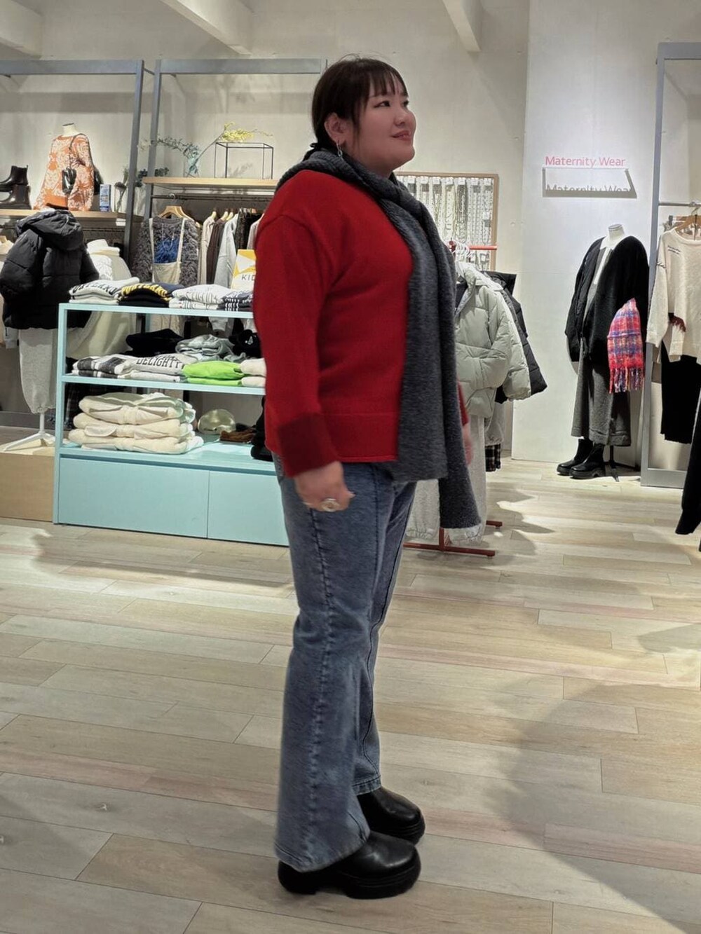 ブラック系のブーツ、レッド系のニット/セーター、ブルー系のマタニティウェア/グッズを着用したレディースの冬コーディネートの2枚目の写真