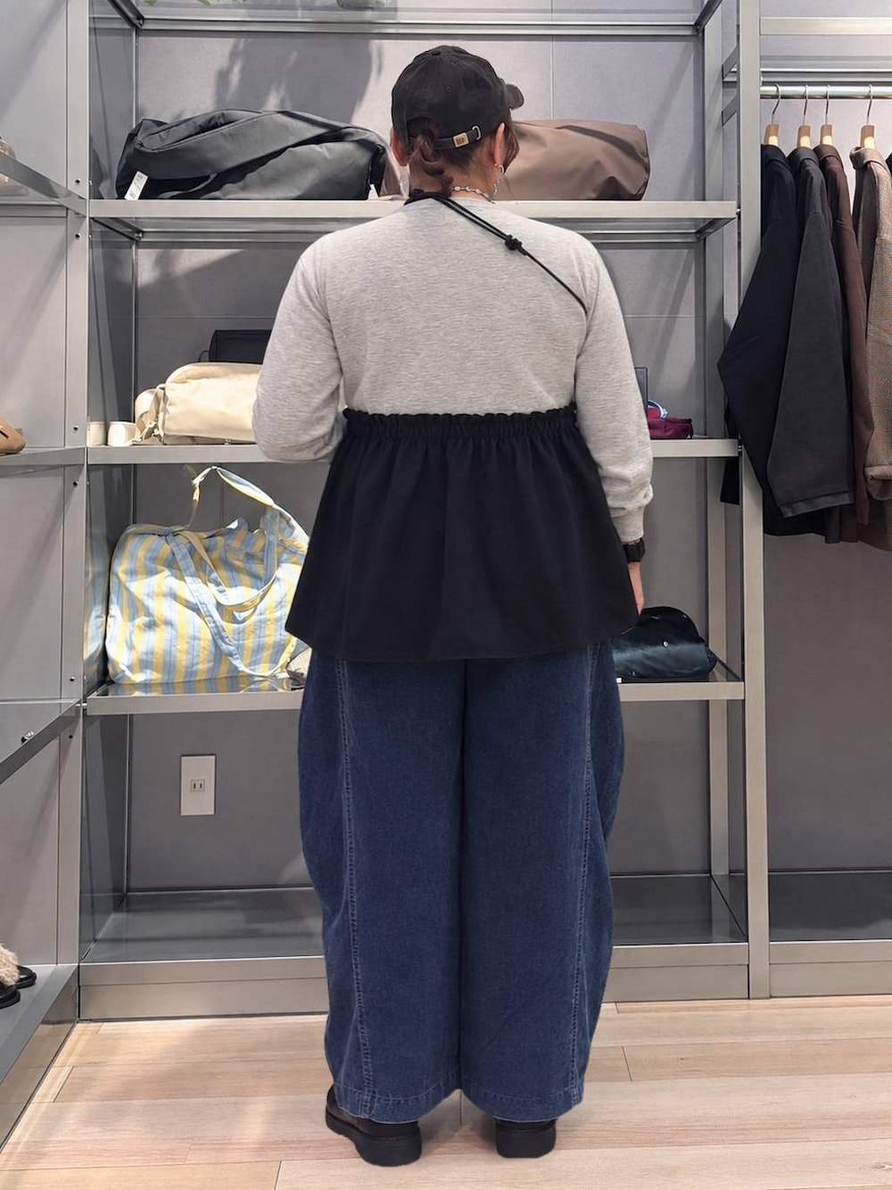 ブルー系のその他パンツ、ブラウン系のキャップ、シルバー系のネックレスを着用したレディースの秋コーディネートの3枚目の写真